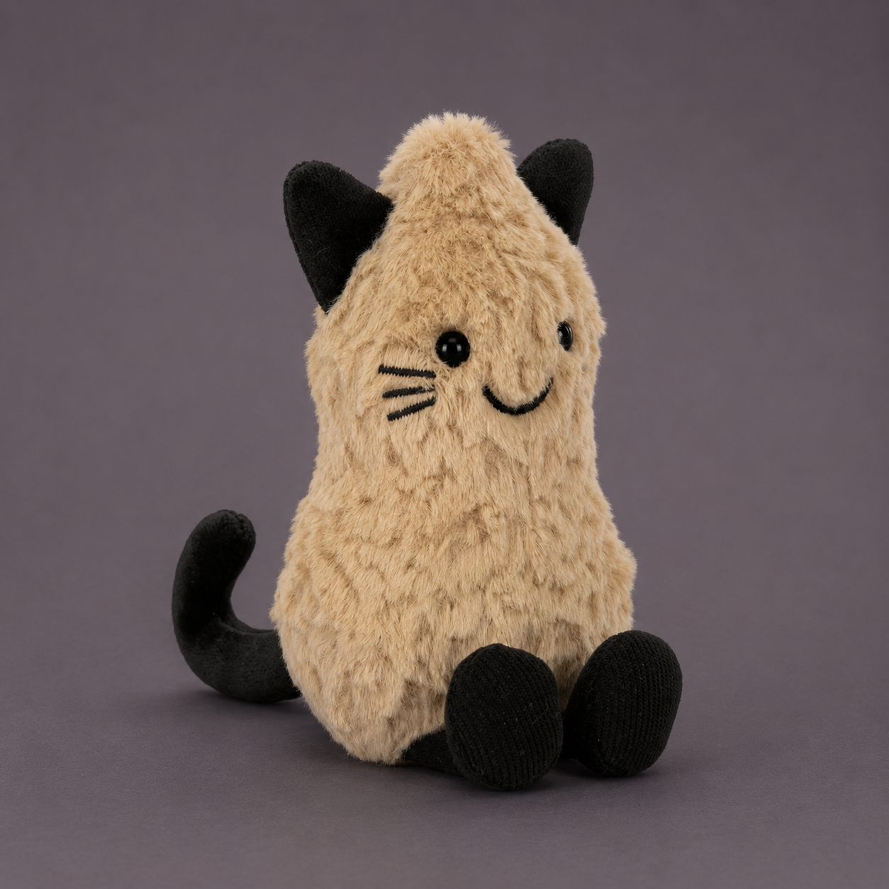 a peanut shaped plush toy wearing a cat costume. 
