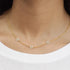 A gold dainty necklace with three daisy shaped group of pearls spaced out on the chain necklace.