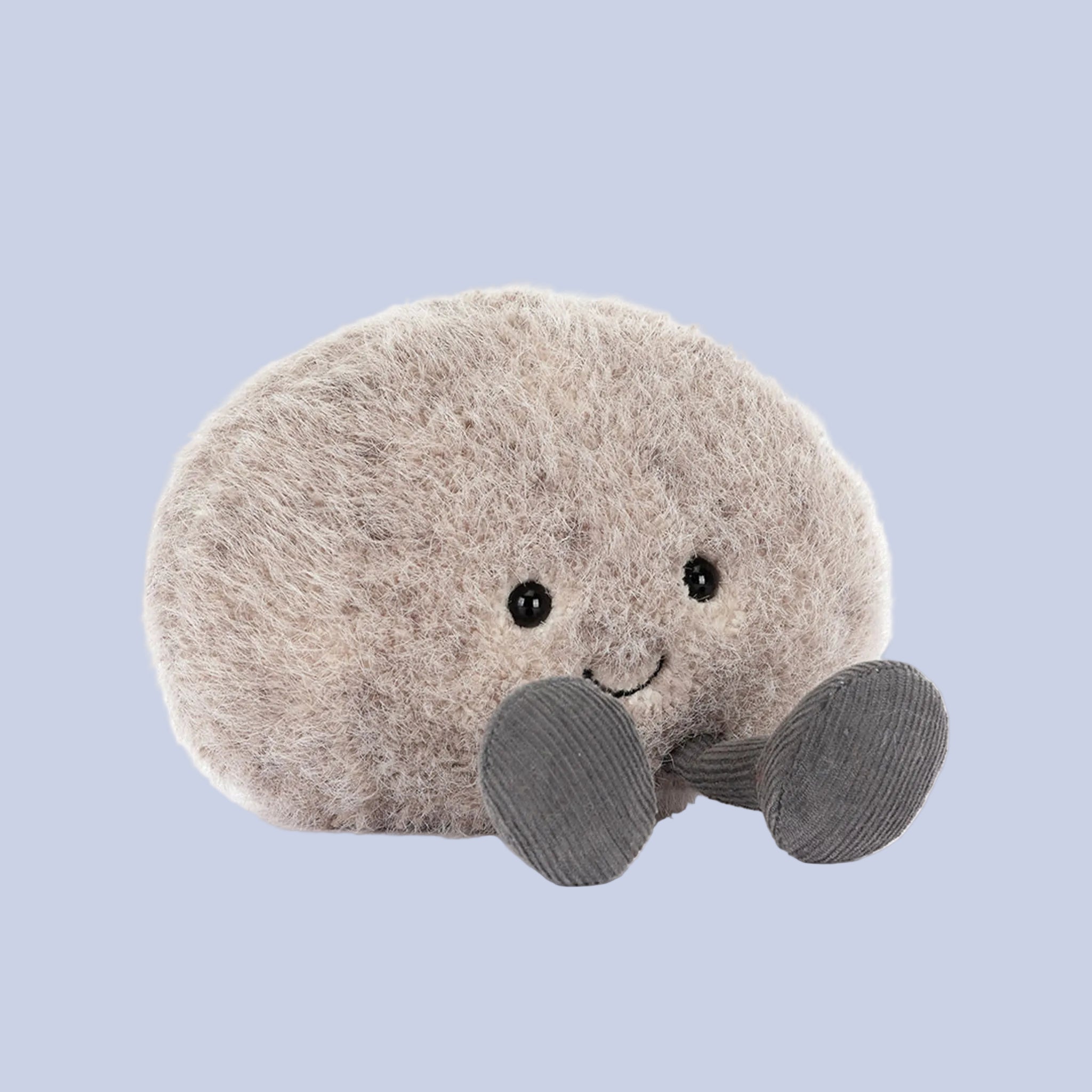 Plush toy resembling a round pebble with a smiling face on a blue background