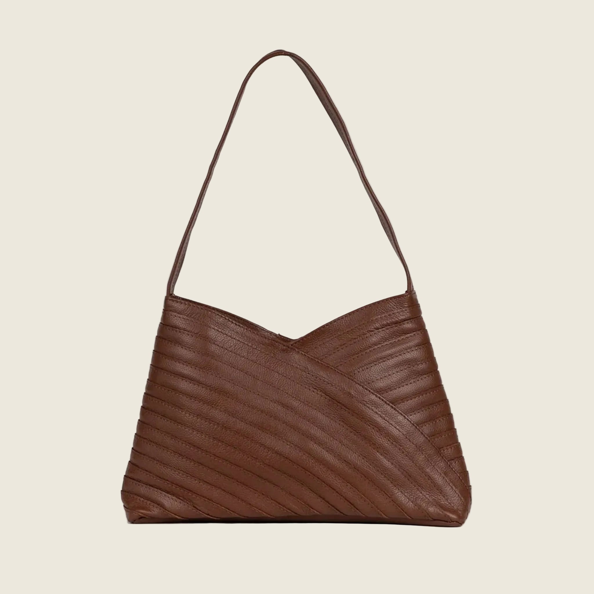 A layered leather handbag with a shoulder strap and a magnetic closure. 