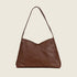 A layered leather handbag with a shoulder strap and a magnetic closure. 