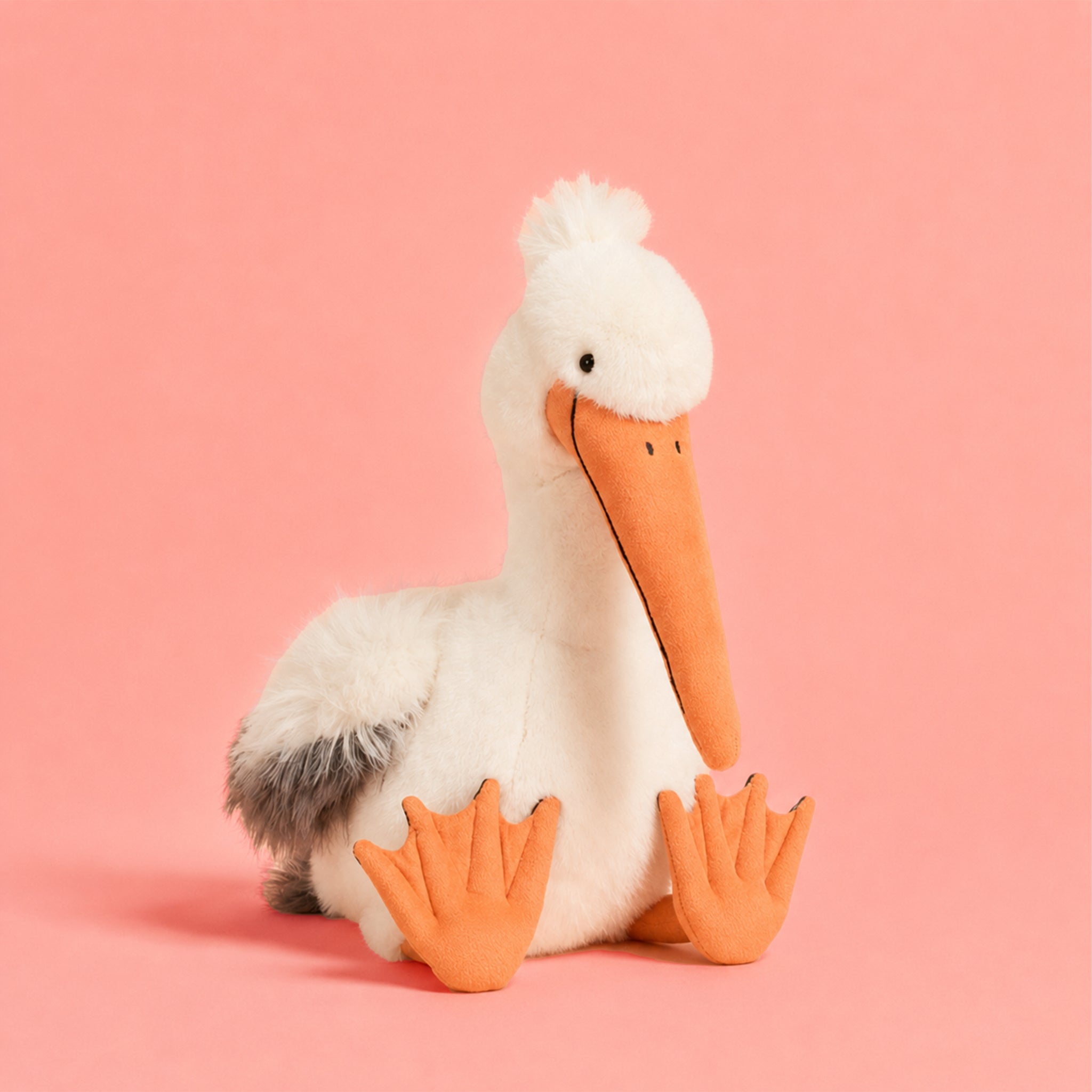 Plush toy pelican on a pink background