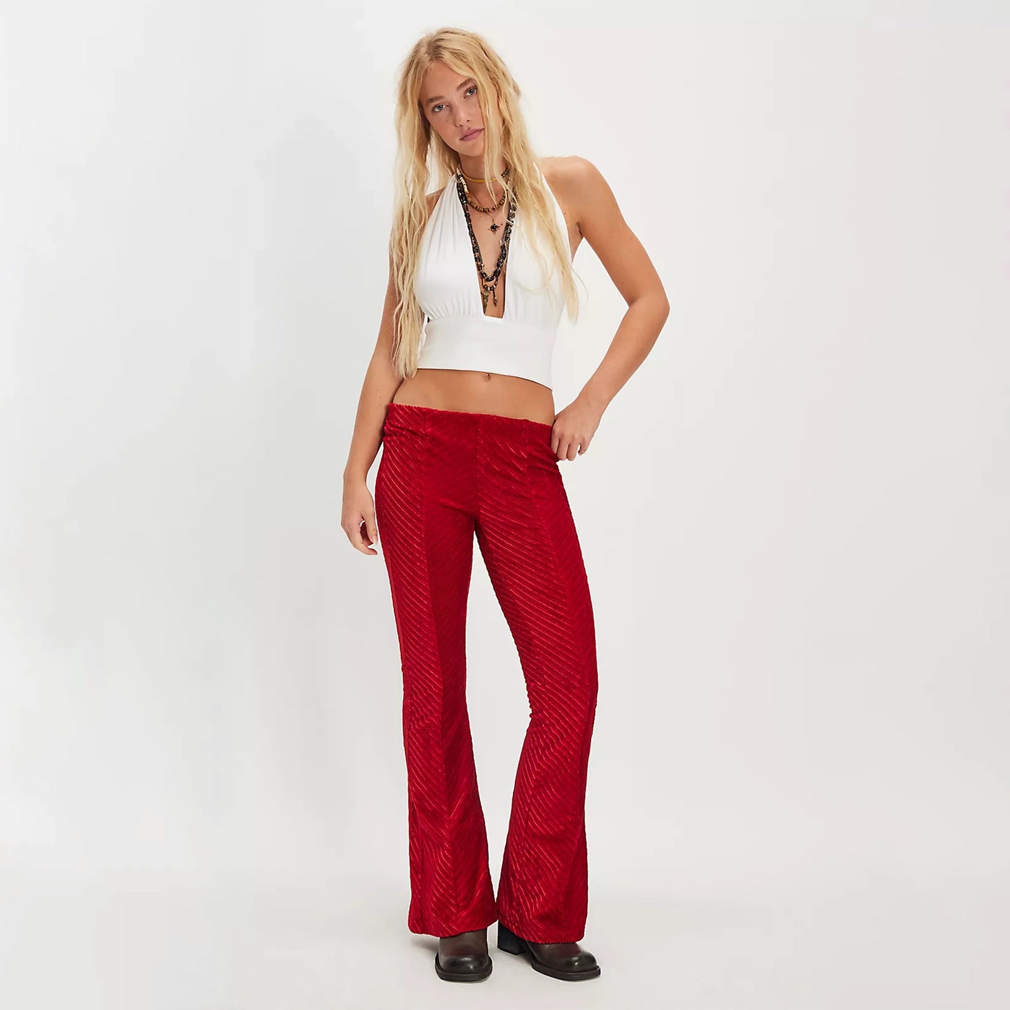 A blonde woman wearing red pair of velvet pull on pants. 