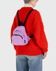  A cool toned pinkish purple mini nylon backpack with black straps and details. 