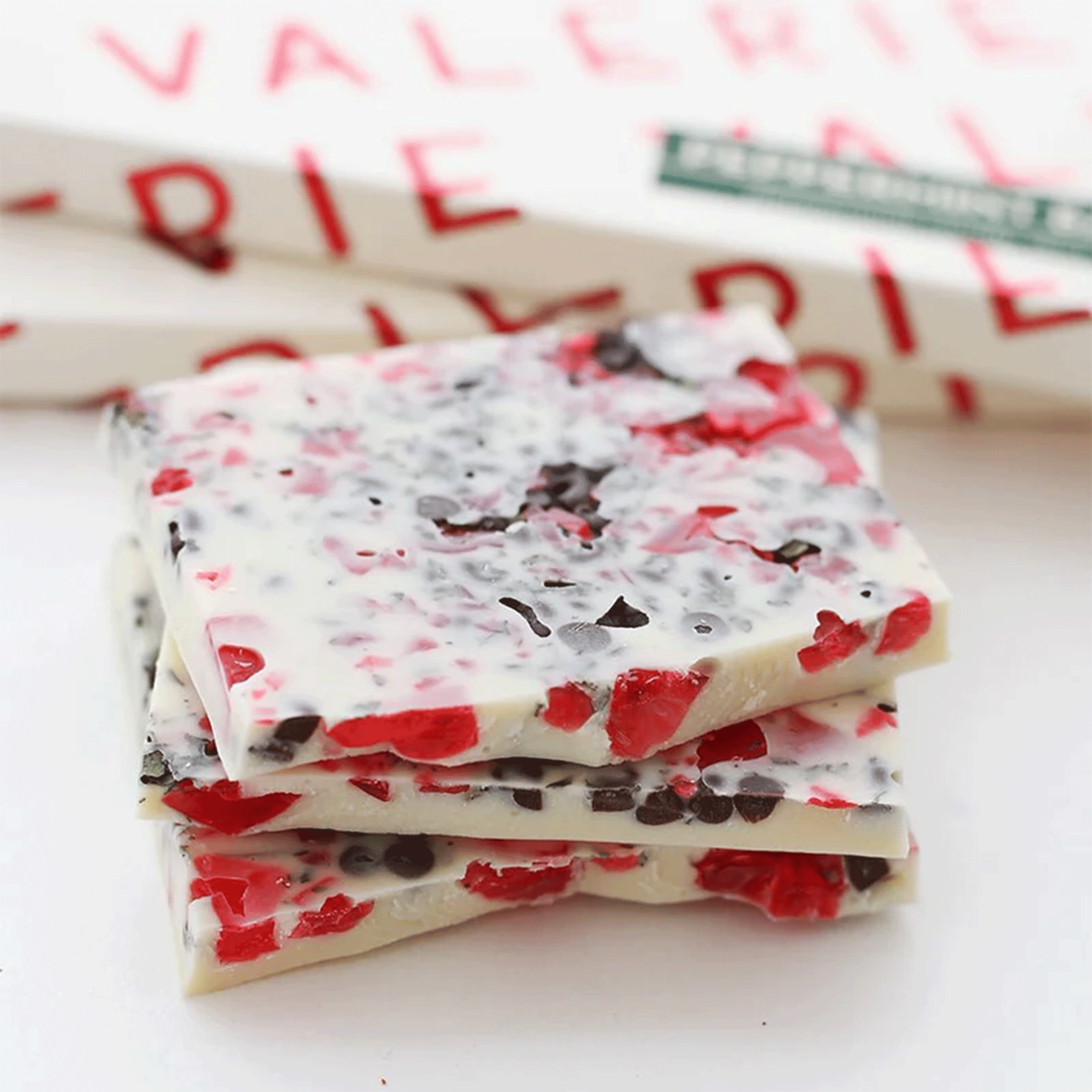 The white chocolate bar broken up to see the inside with pieces of peppermint. 