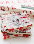 The white chocolate bar broken up to see the inside with pieces of peppermint. 
