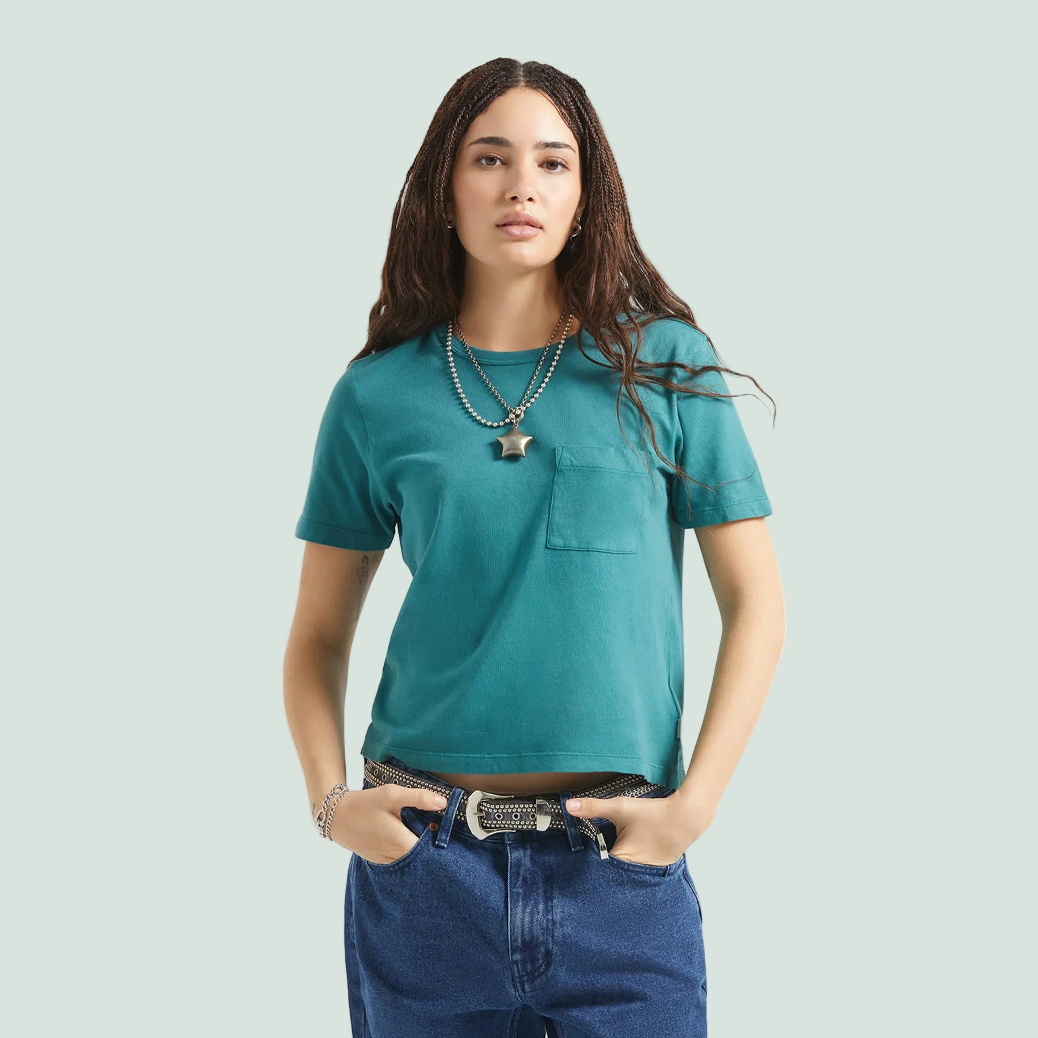 A teal blue short sleeve shirt with a front pocket. 