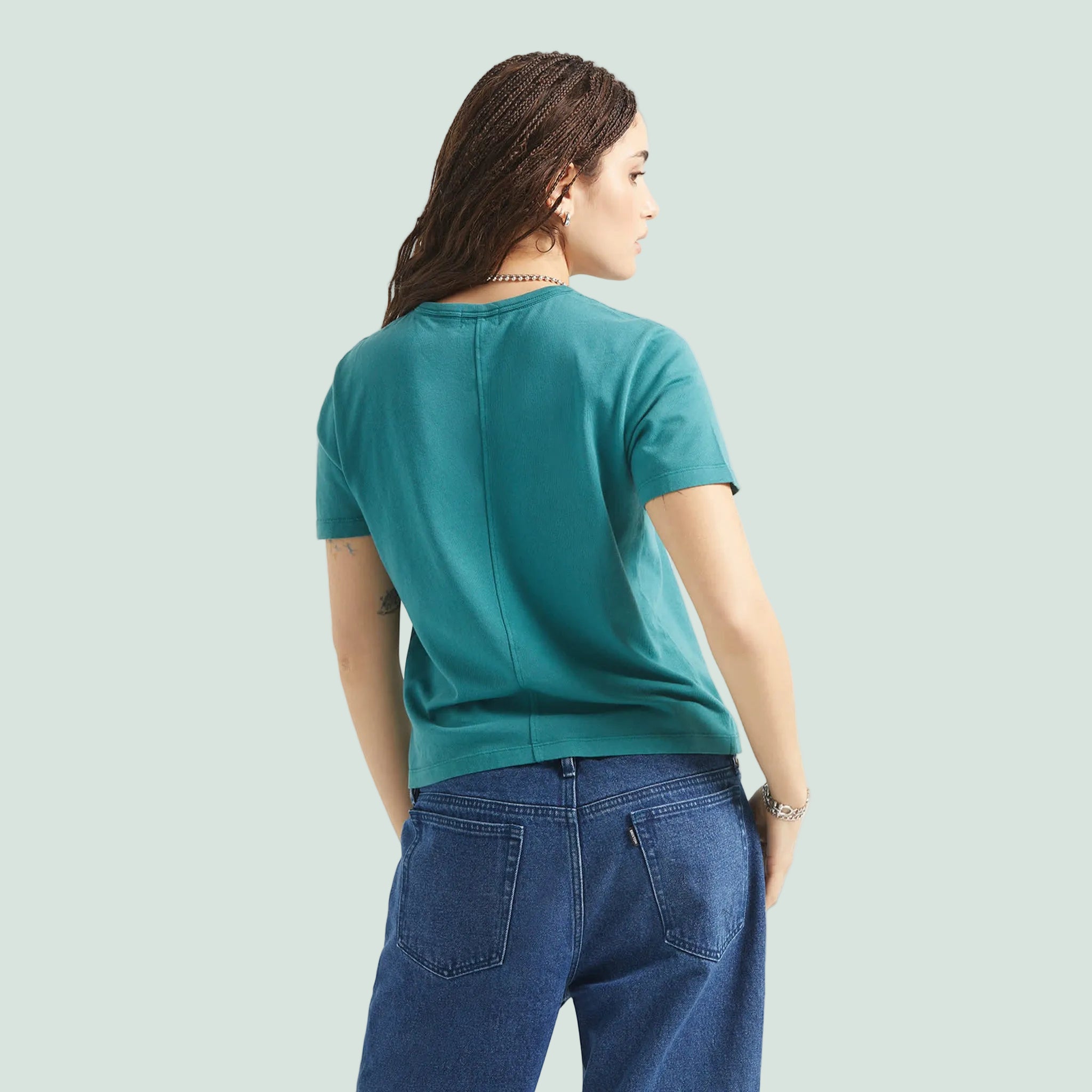 A teal blue short sleeve shirt with a front pocket. 
