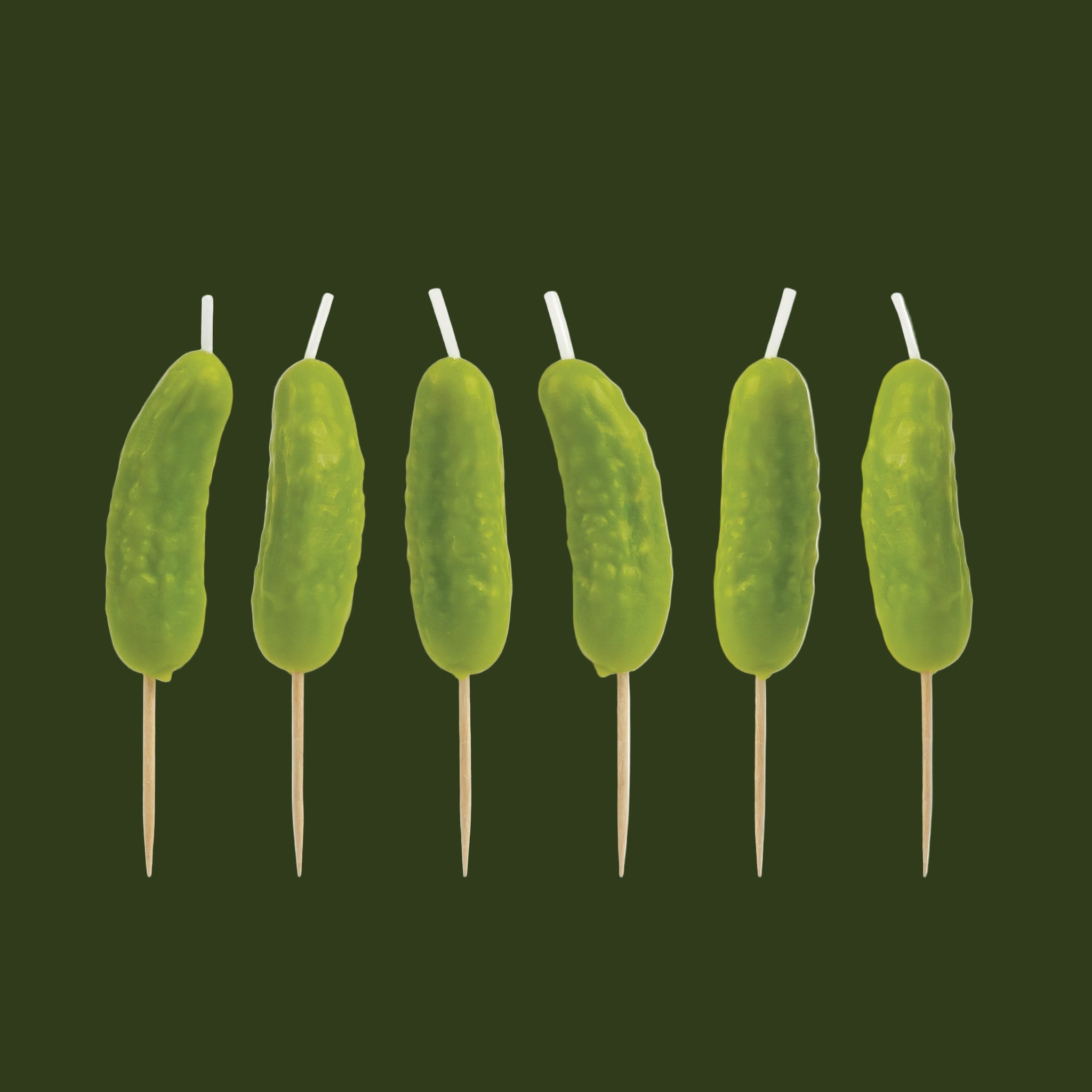 A set of six pickle shaped cake candles. 