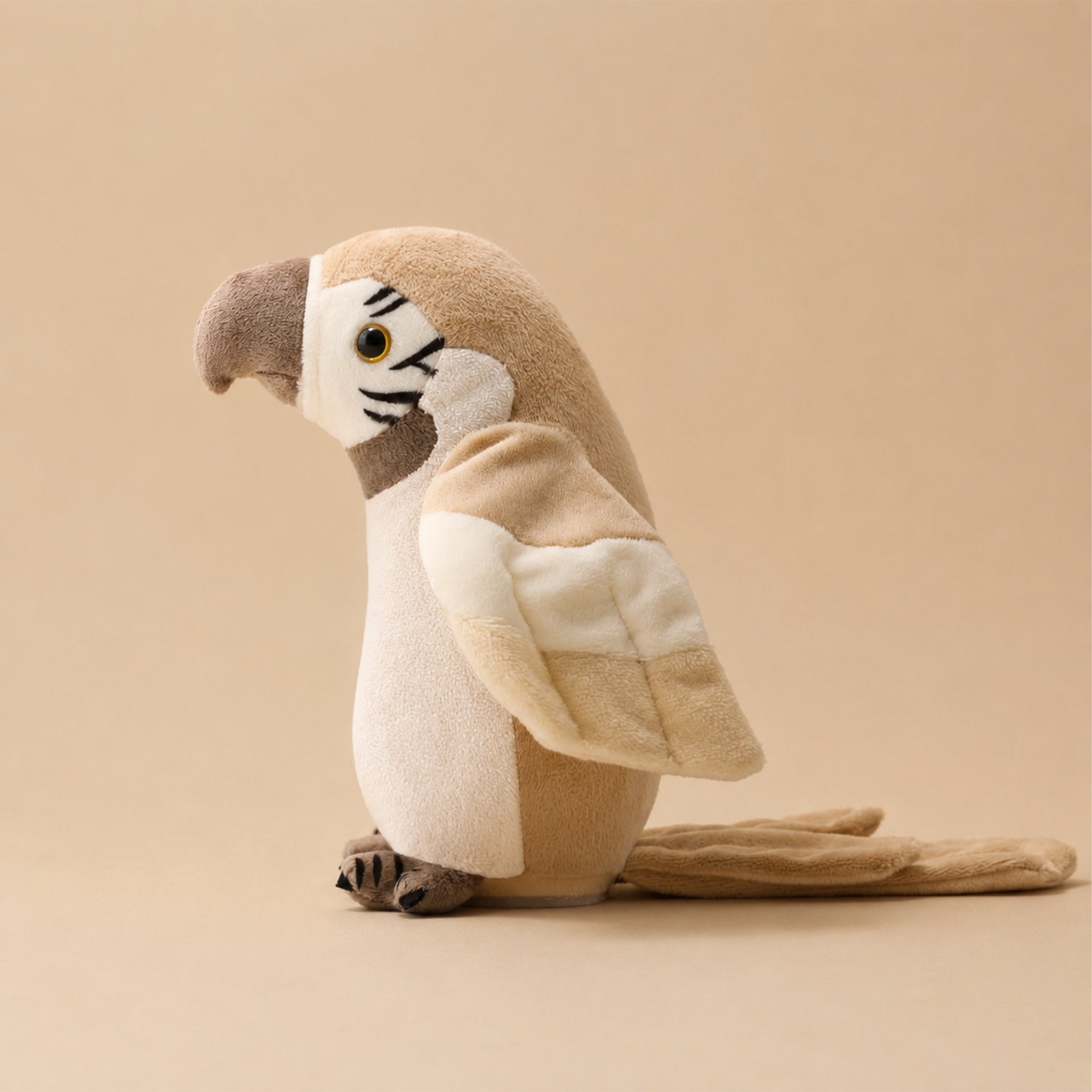 A tan parrot plush toy on a tan background. 