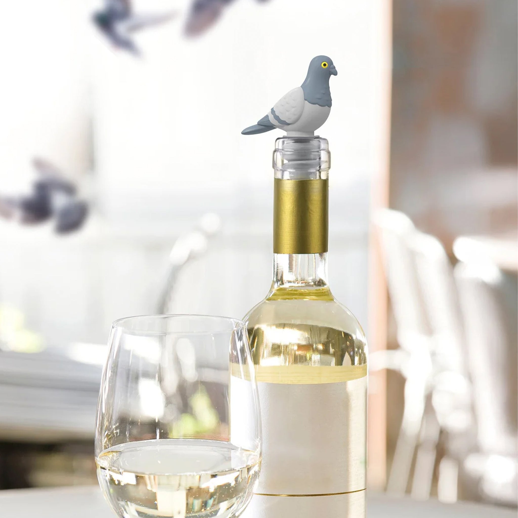 A grey pigeon shaped bottle stopper. 