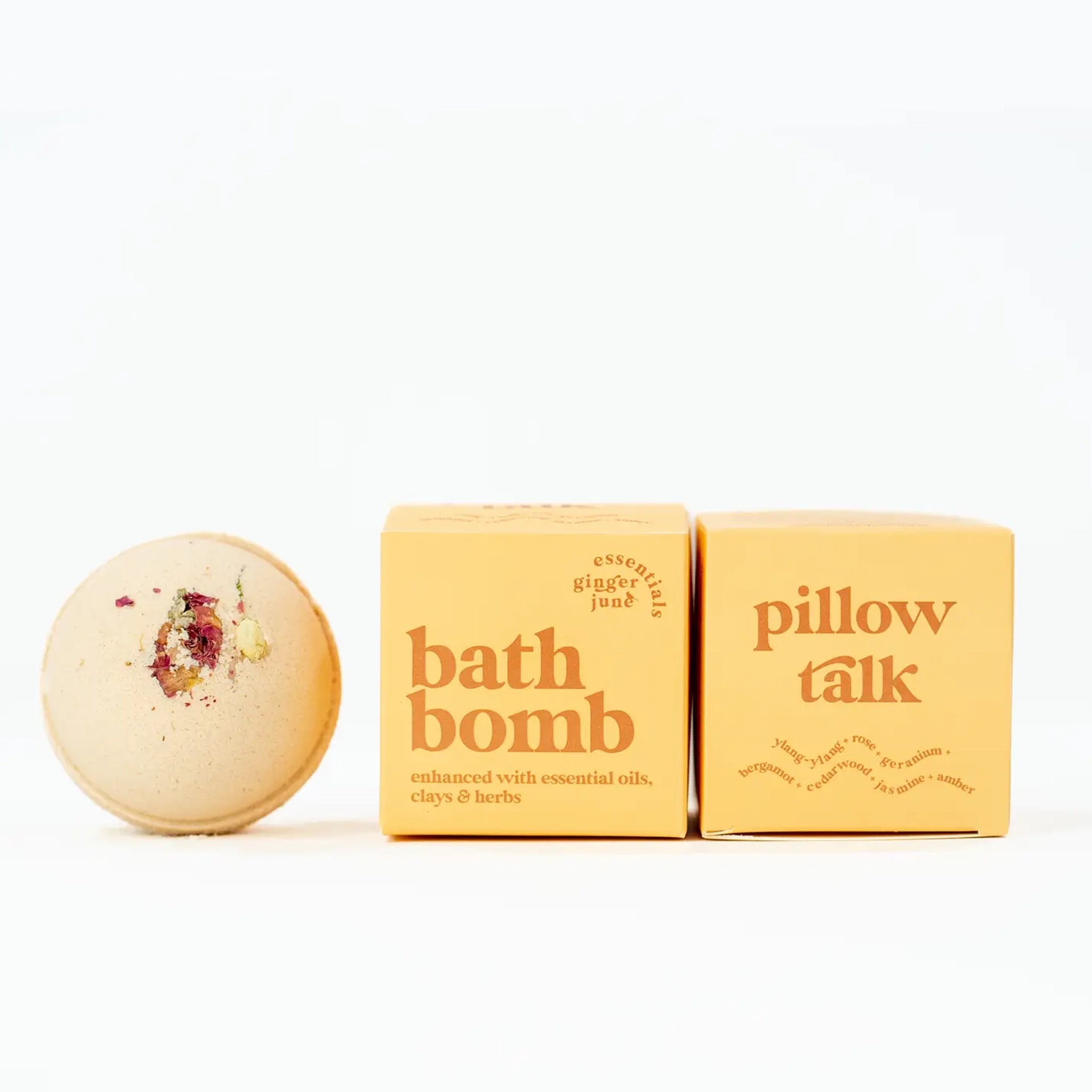 On a white background is a yellow bath bomb with a yellow box beside it that reads, "bath bomb enhanced with essential oils, clays and herbs". 