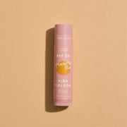 Pink lip balm with 'Pina Colada' flavor on a beige background