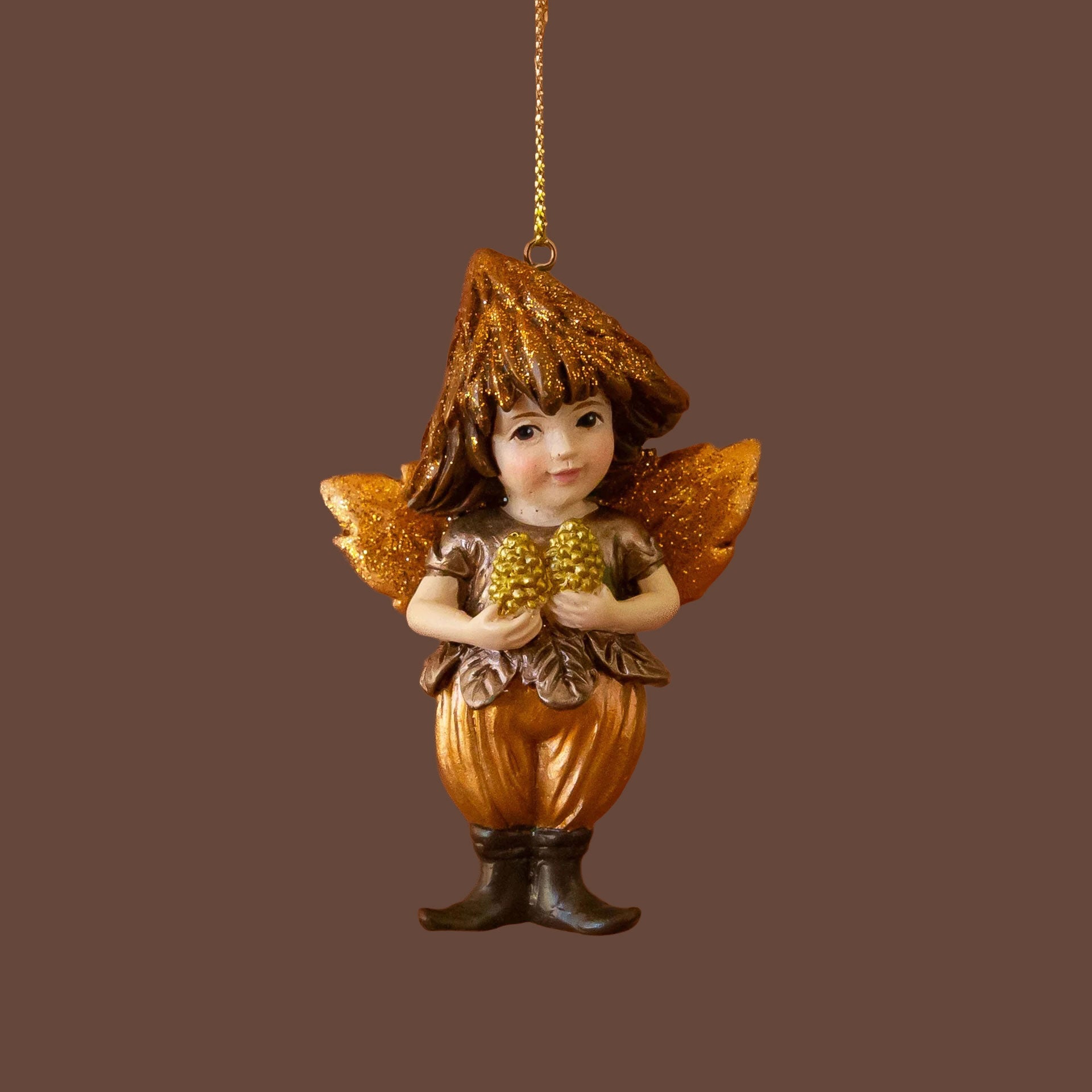 A woodland fairy shaped ornament with brown and copper details holding pinecones. 