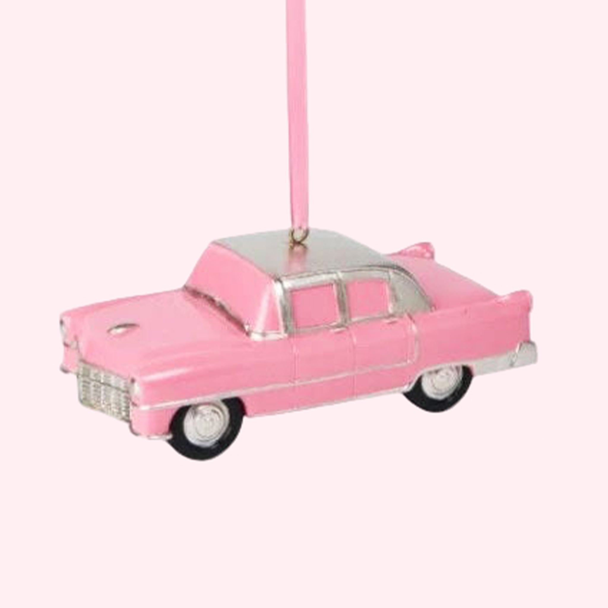 Pink cadillac shaped ornament on a pink background.
