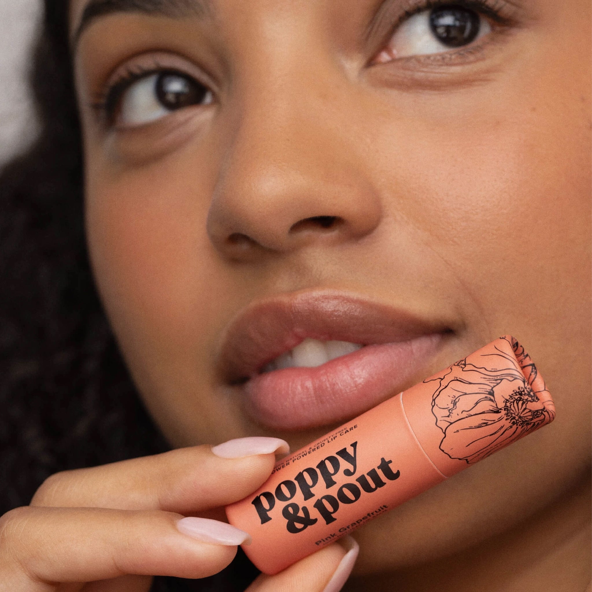 A box filled with a lip scrub and apricot colored lip balm tube. 