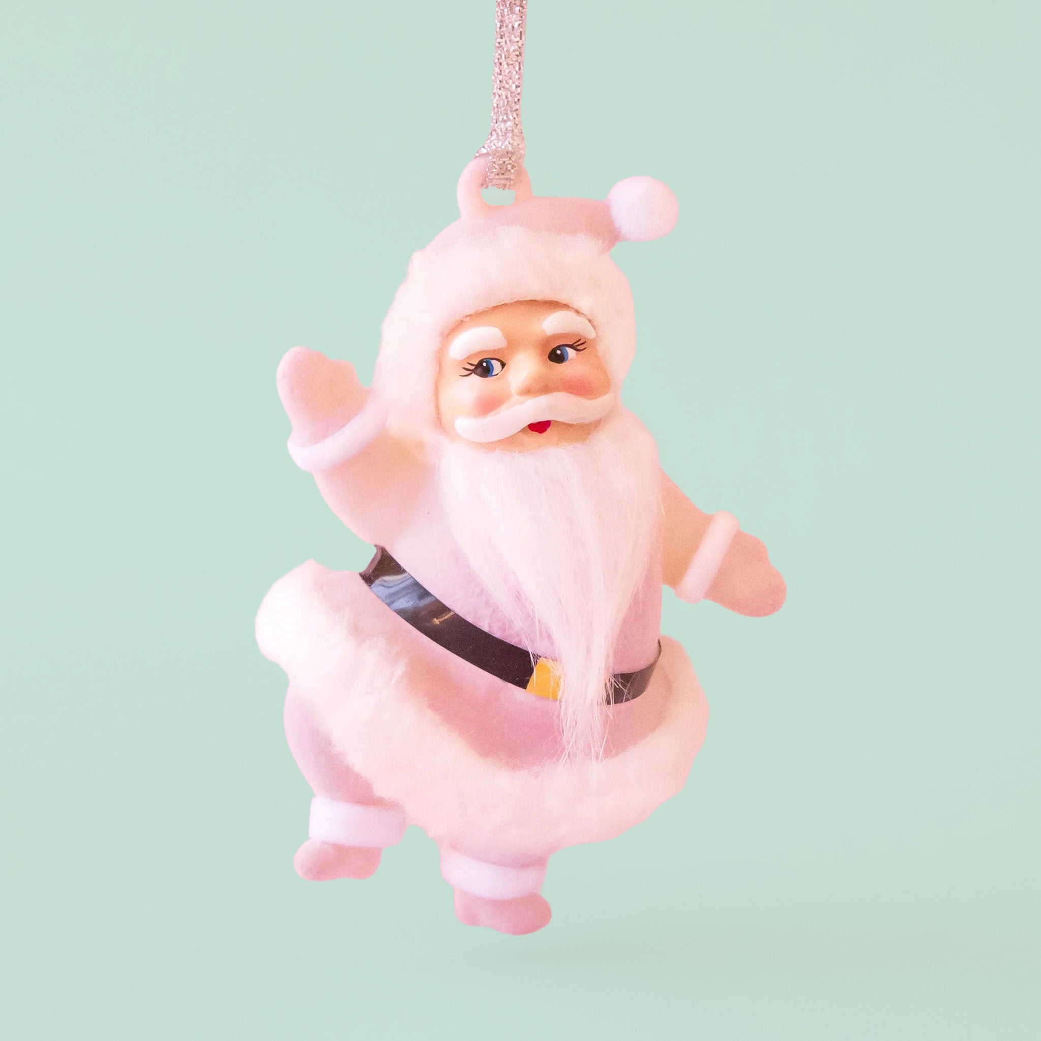 santa figure ornament with a light pink coat on a mint background.
