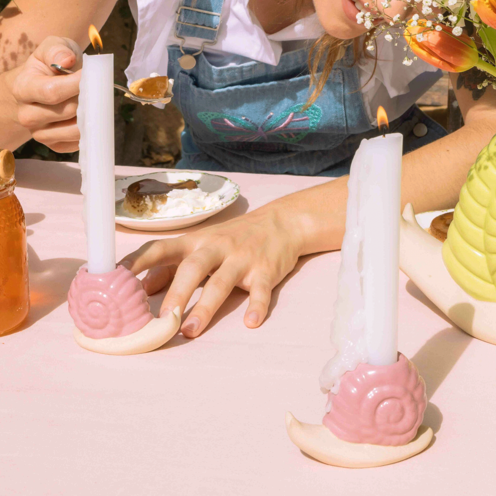 A photo of a table scape with the pink snail shaped candle holder.
