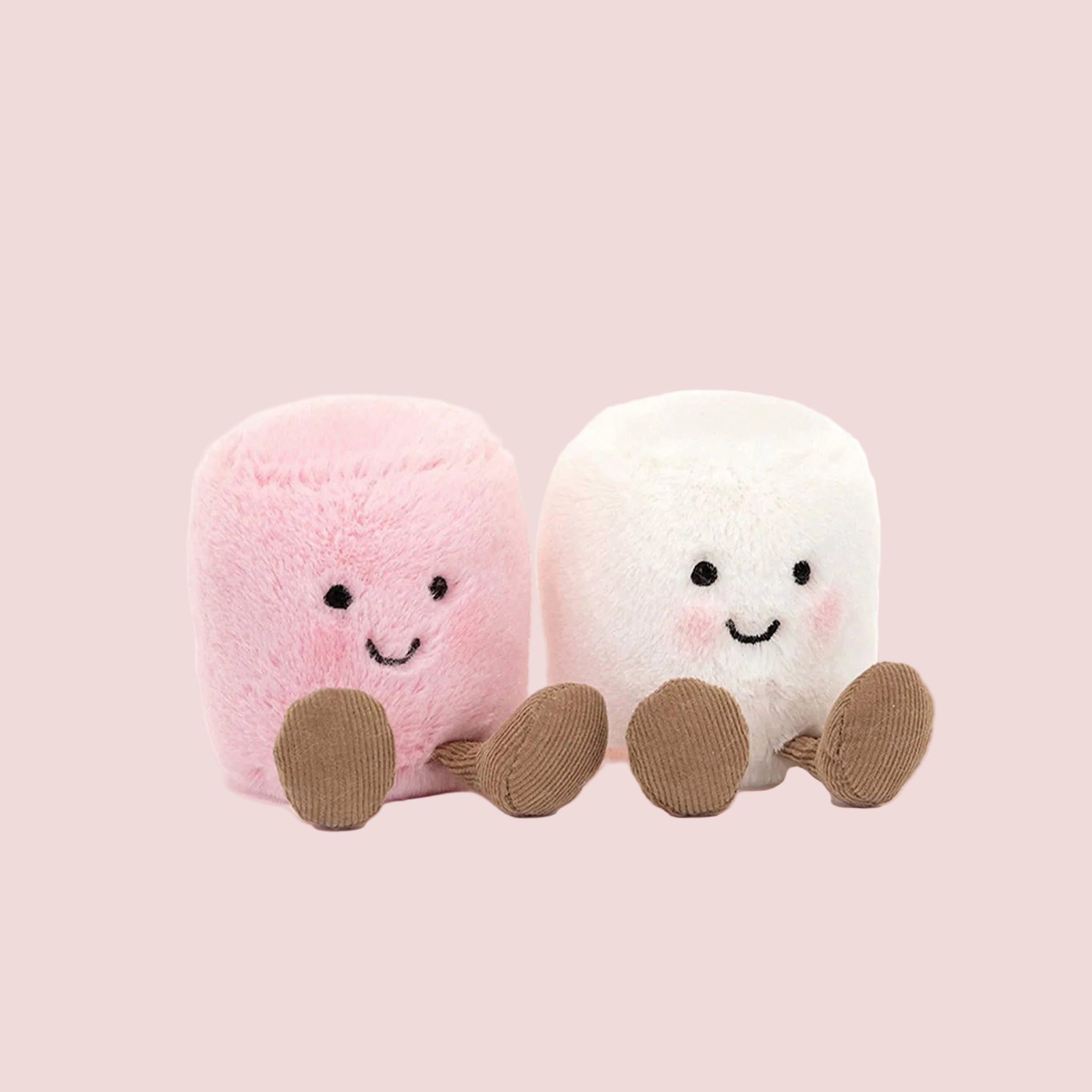 Two plush toys, one pink and one white, with smiling faces on a white background