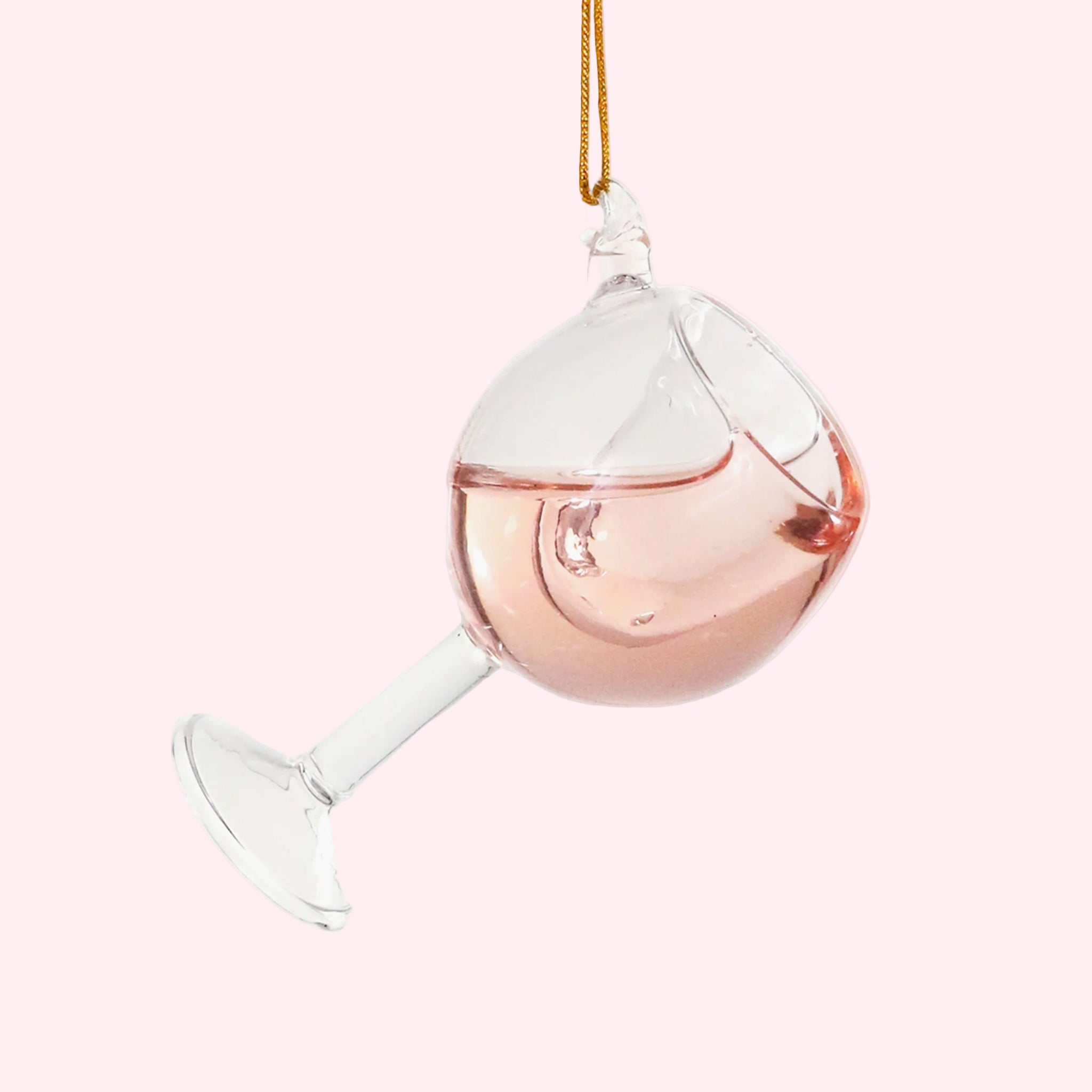 A glas ornament in the shape of a wine glass with pink liquid on the inside. 