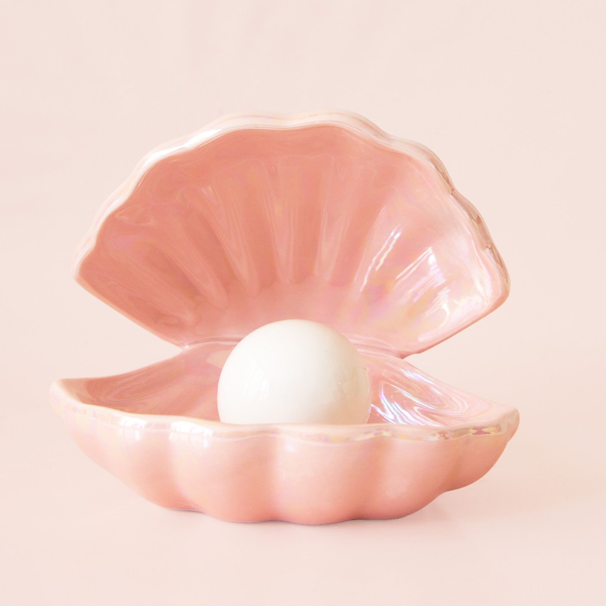 Pink shell with a pearl inside on a light pink background