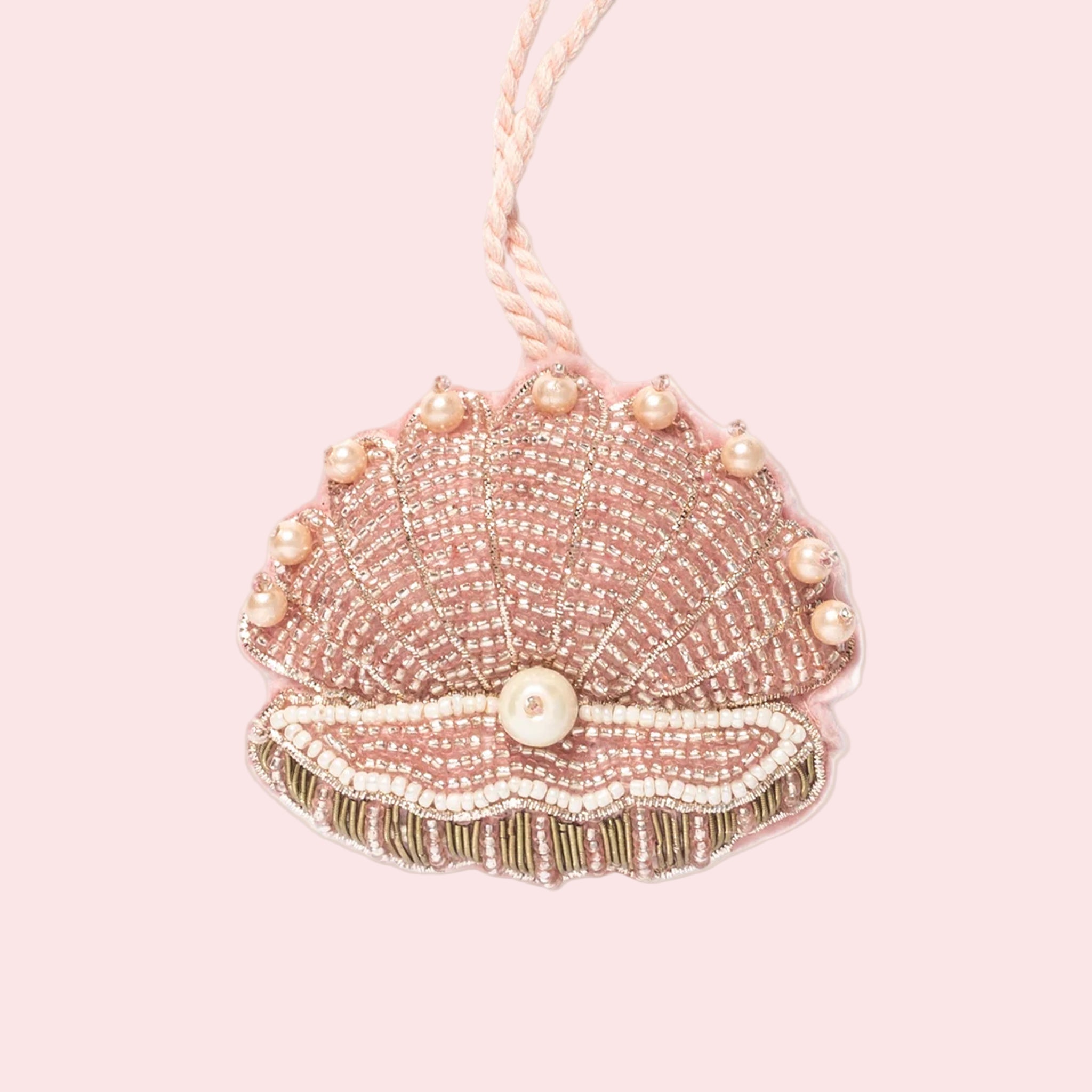 A pink beaded clam shell shaped ornament. 