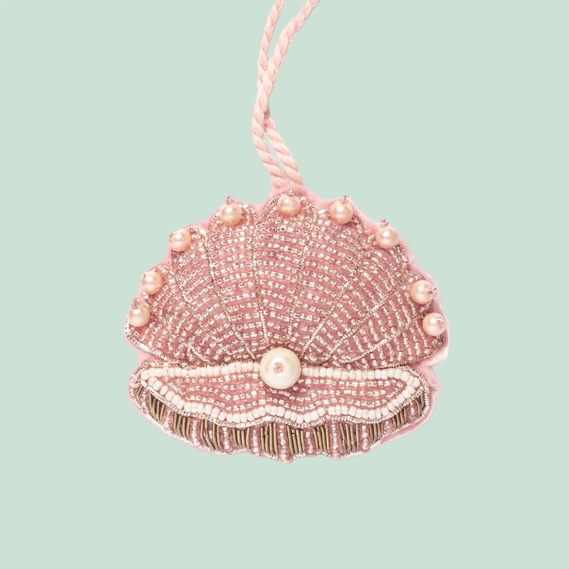 A pink beaded clam shell shaped ornament. 