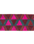 A pink, red, rust and teal triangle patterned bath mat with tassel details on the two ends.