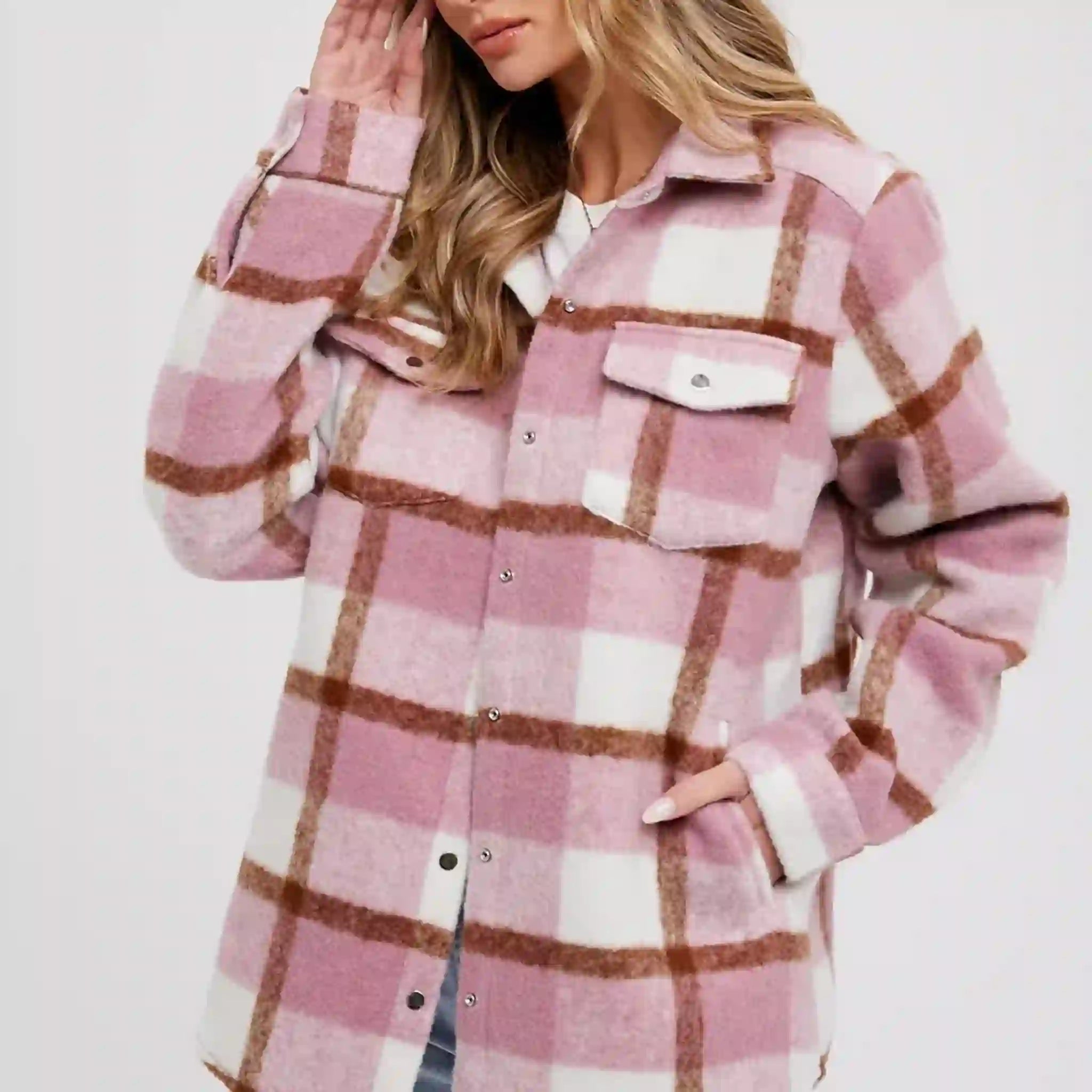 On a white background is a pink and white plaid shacked with front pockets. 