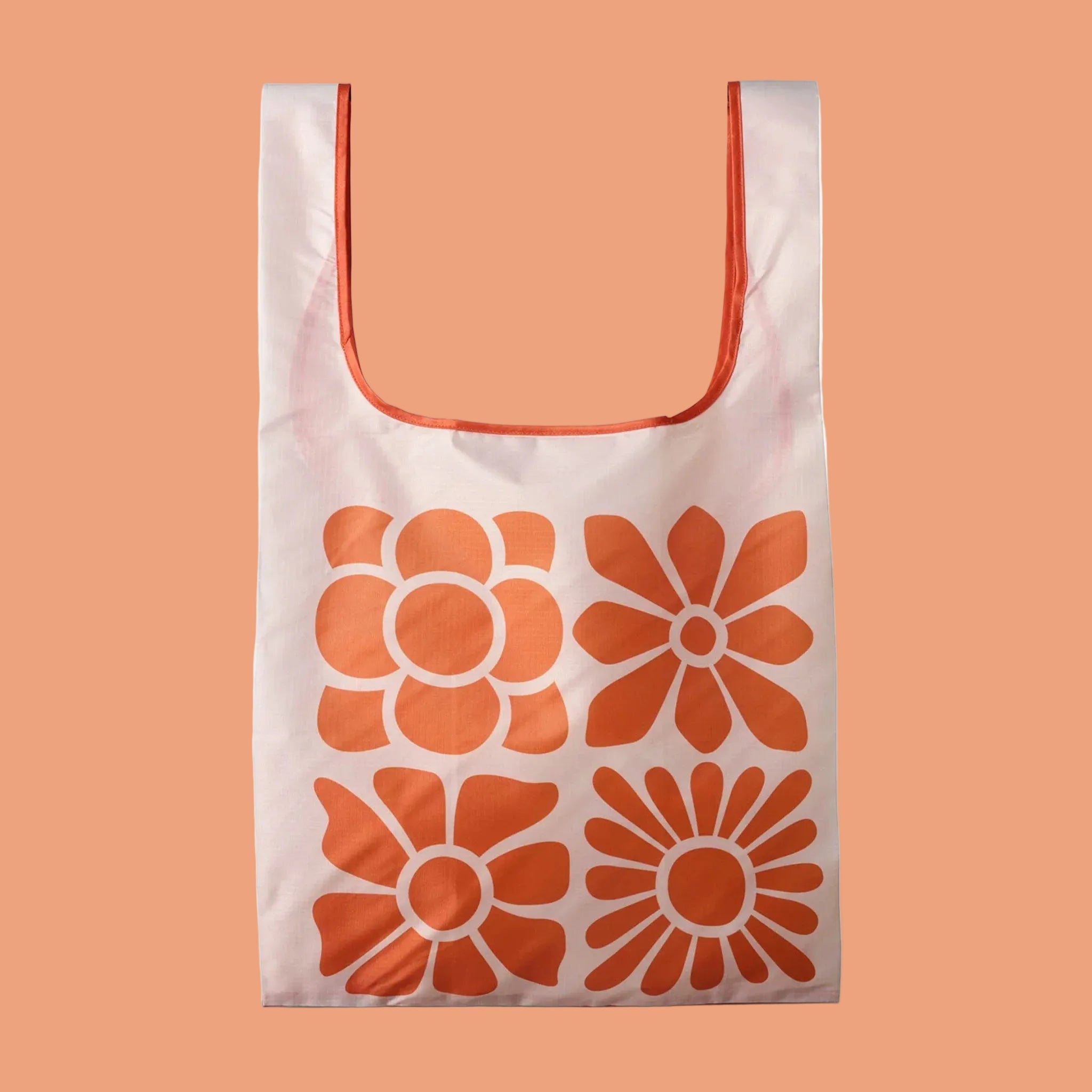 An orange foldable tote bag with a neutral large floral pattern. 