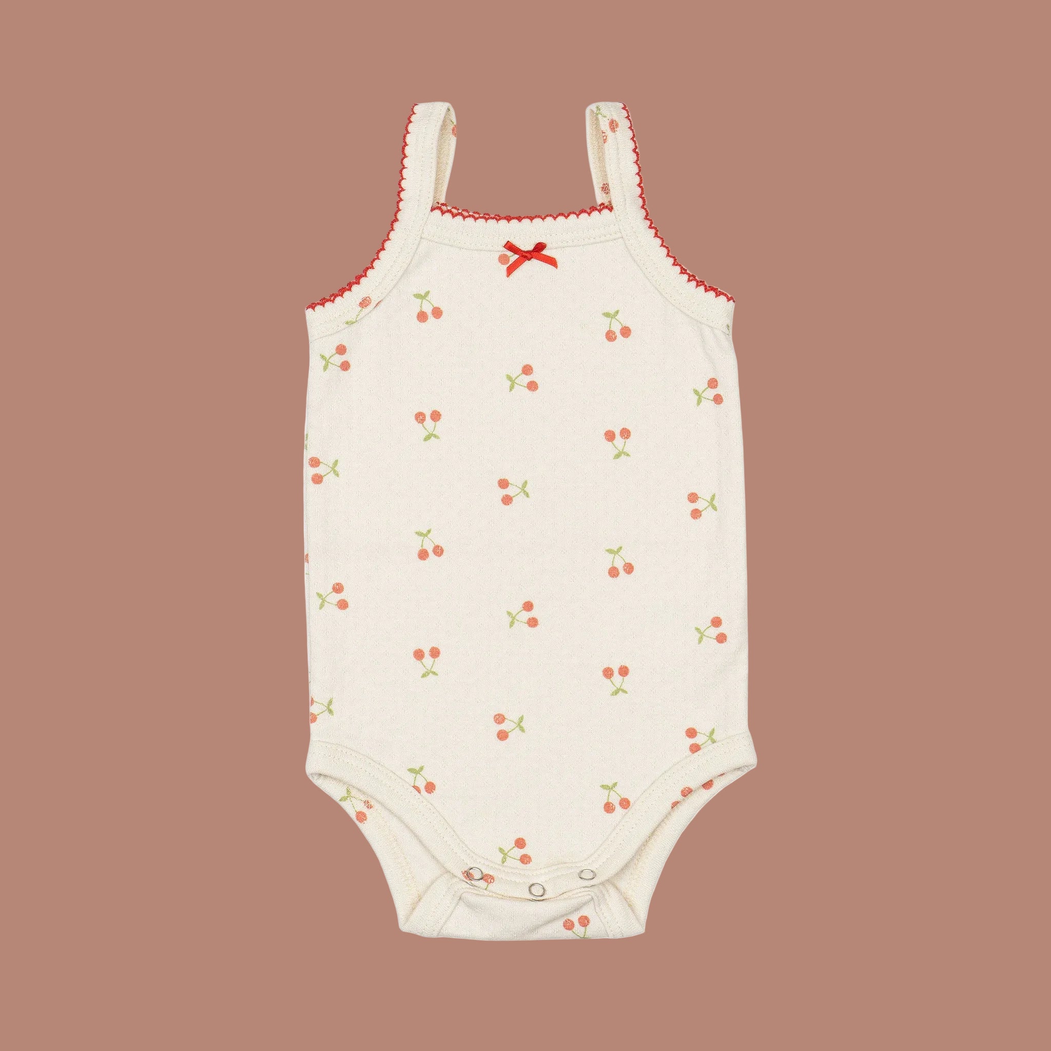 An ivory onesie with a cherry print. 