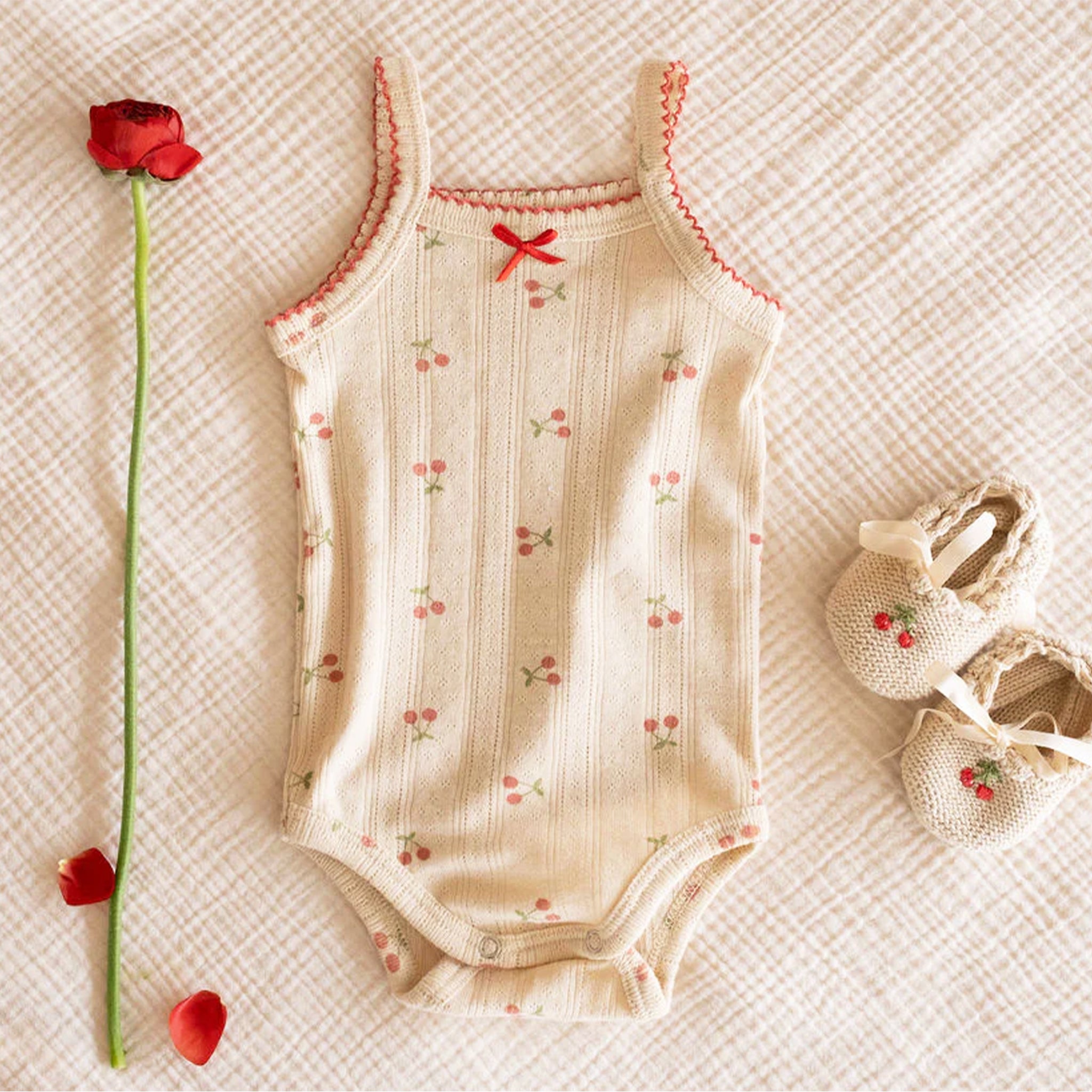 An ivory onesie with a cherry print. 