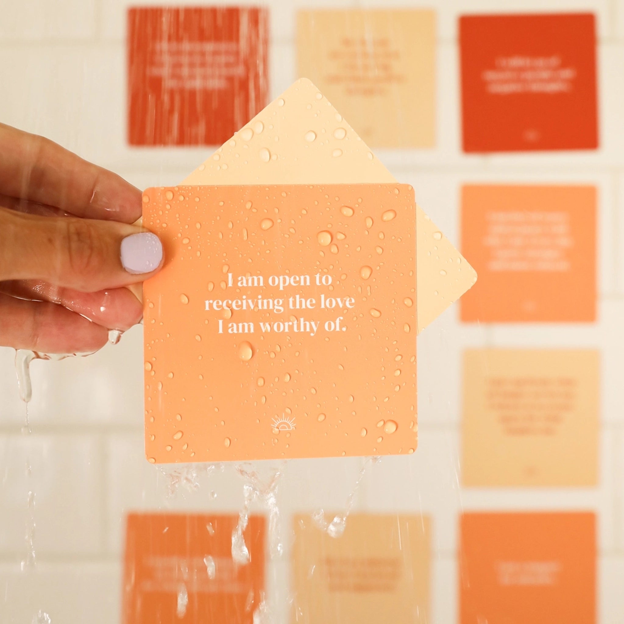 Cards with affirmations related to positivity in different shades of orange along with a shower steamer.