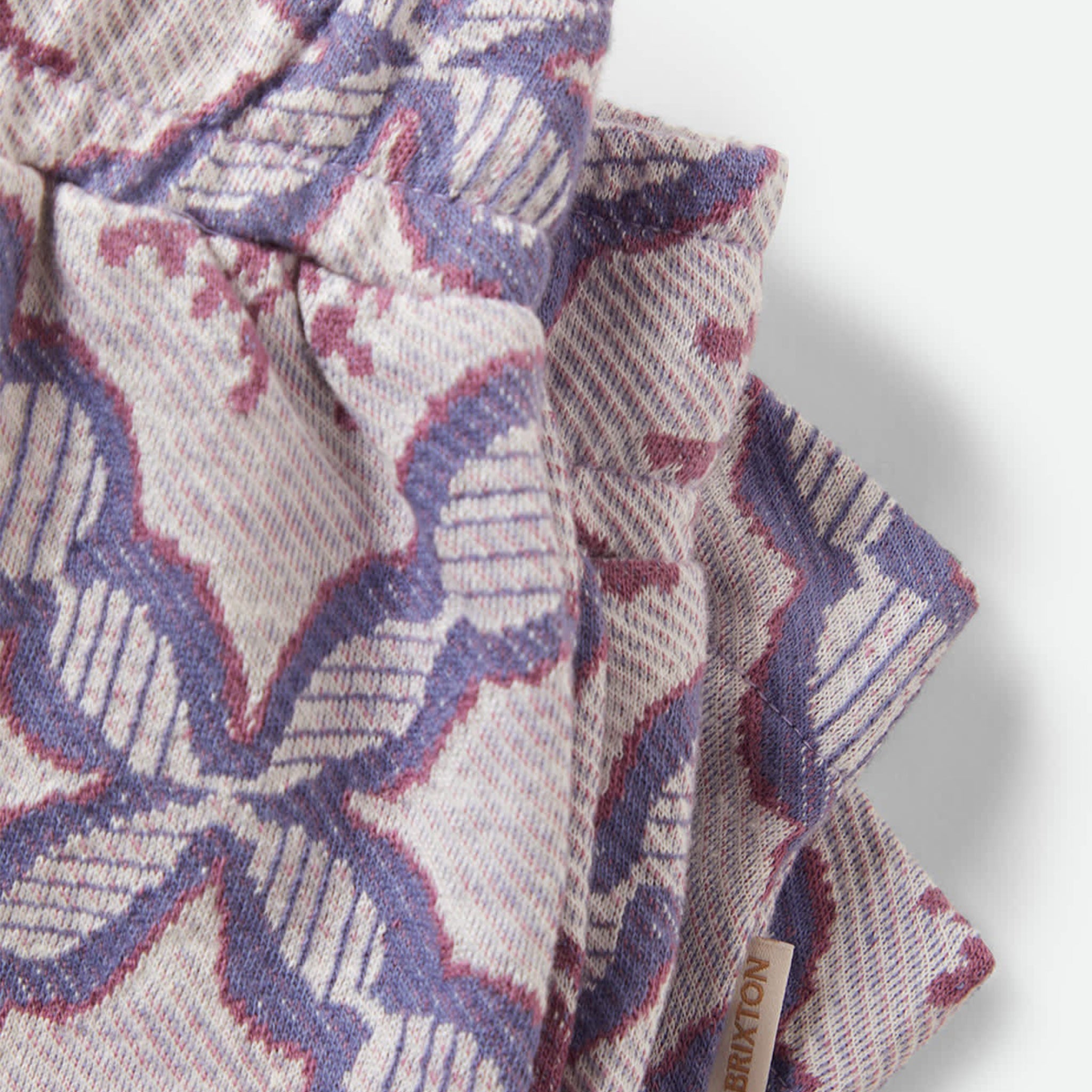 Patterned fabric with a visible brand tag on a white background