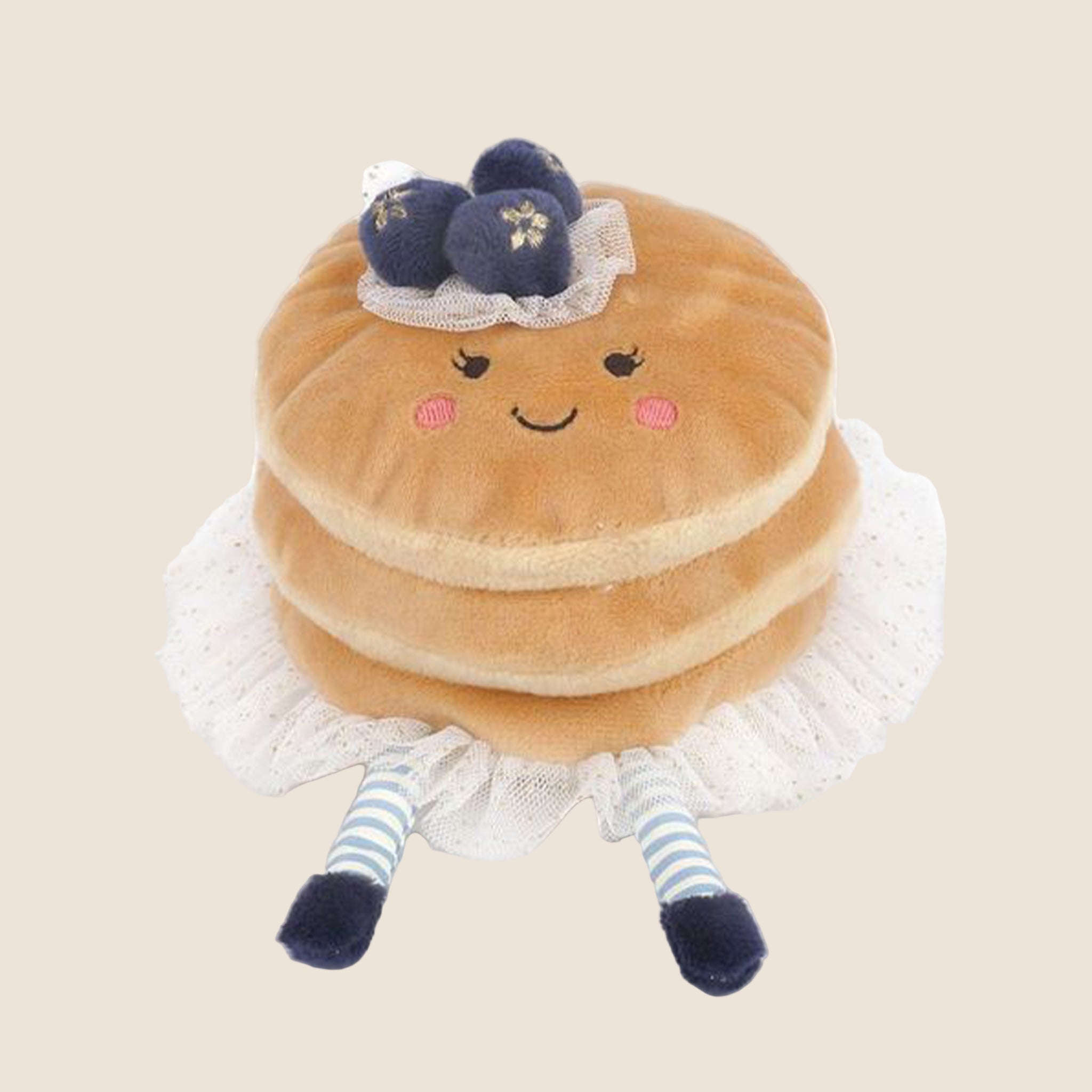 A pancake shaped stuffed toy with a smiling face and striped arms and legs. 