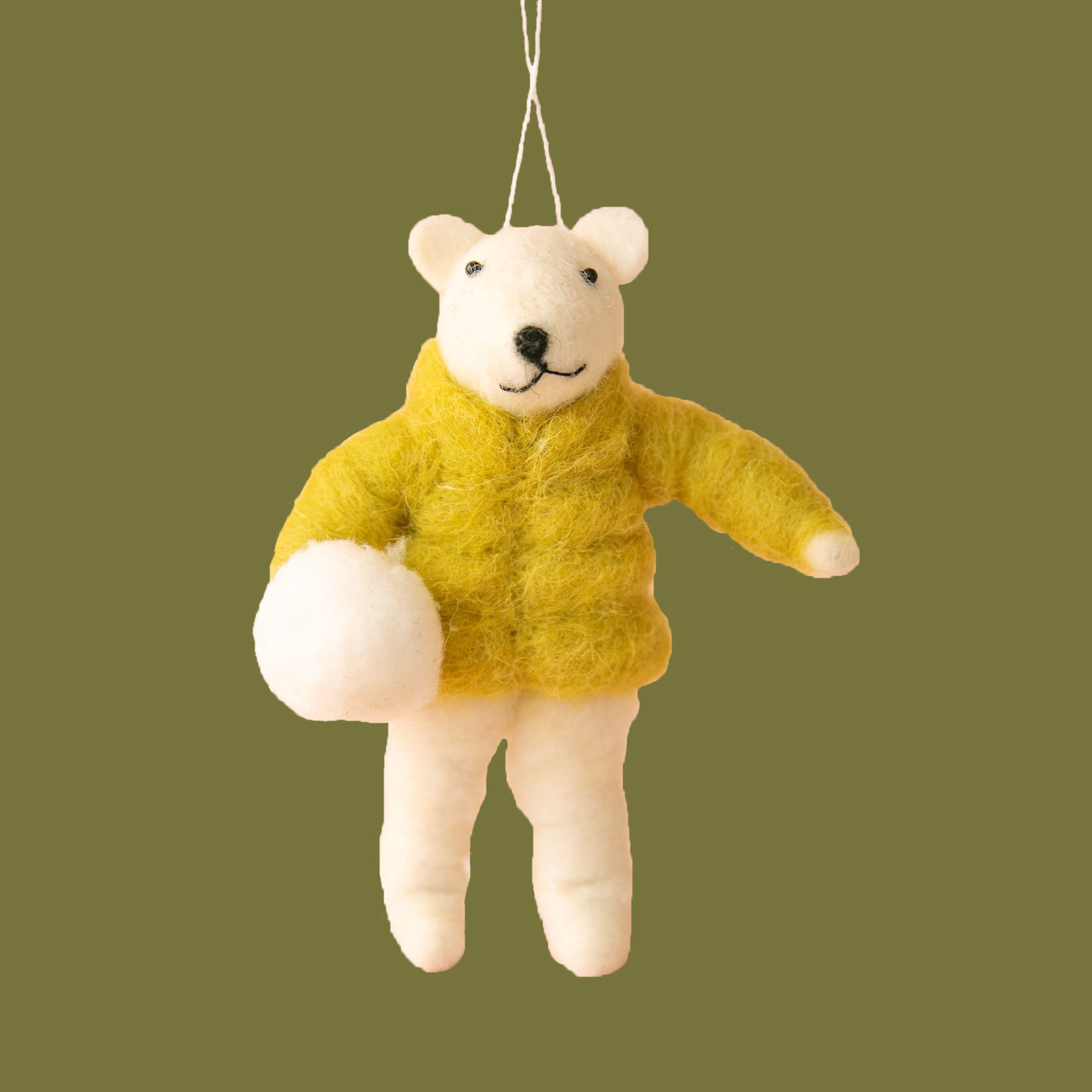 On a peachy background is a white felt bear ornament wearing a yellow puffy jacket. 