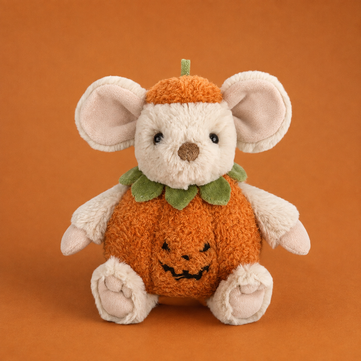 A beige mouse shaped stuffed animal toy with an orange outfit. 