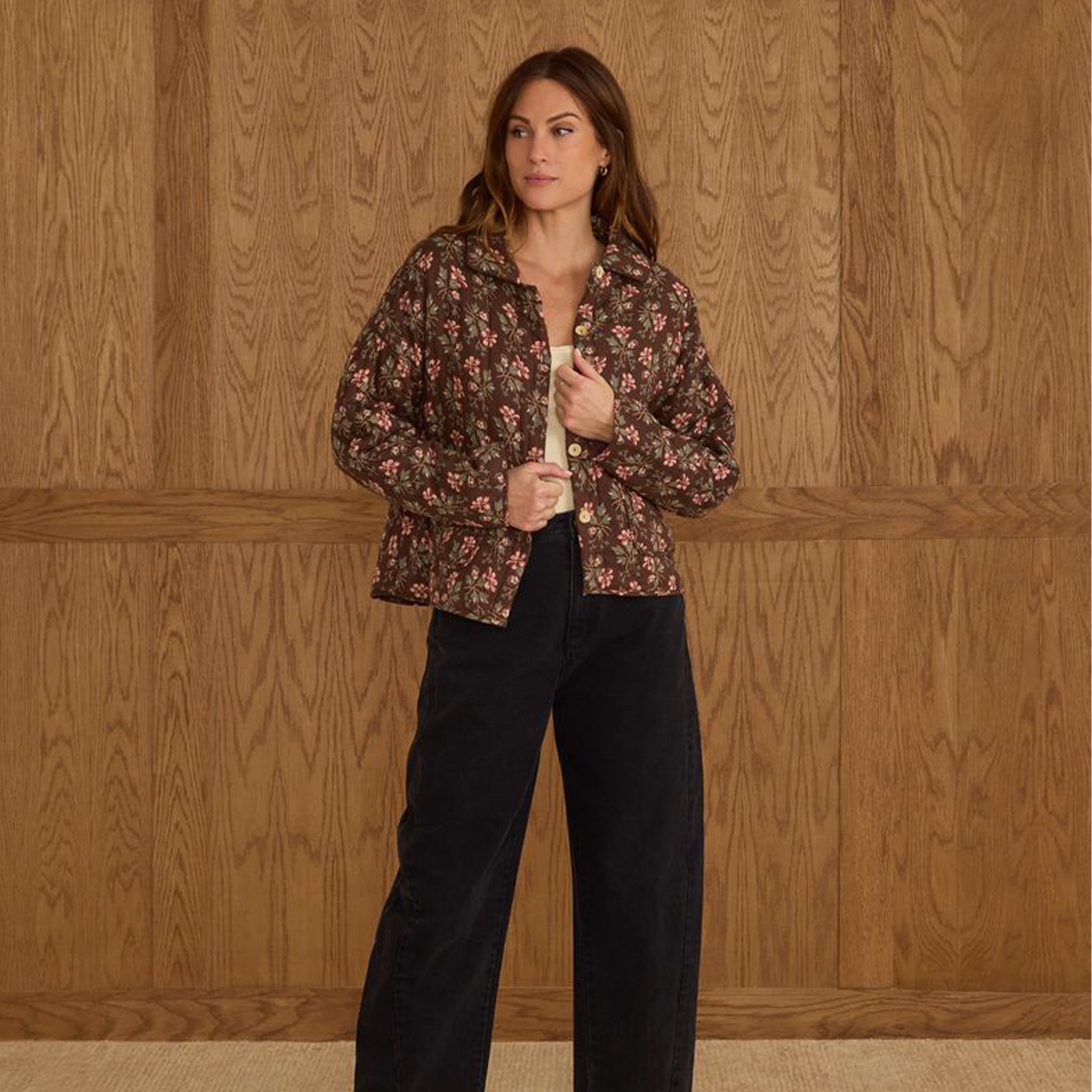 A brown quilted jacket with a pink and ivory floral print. 