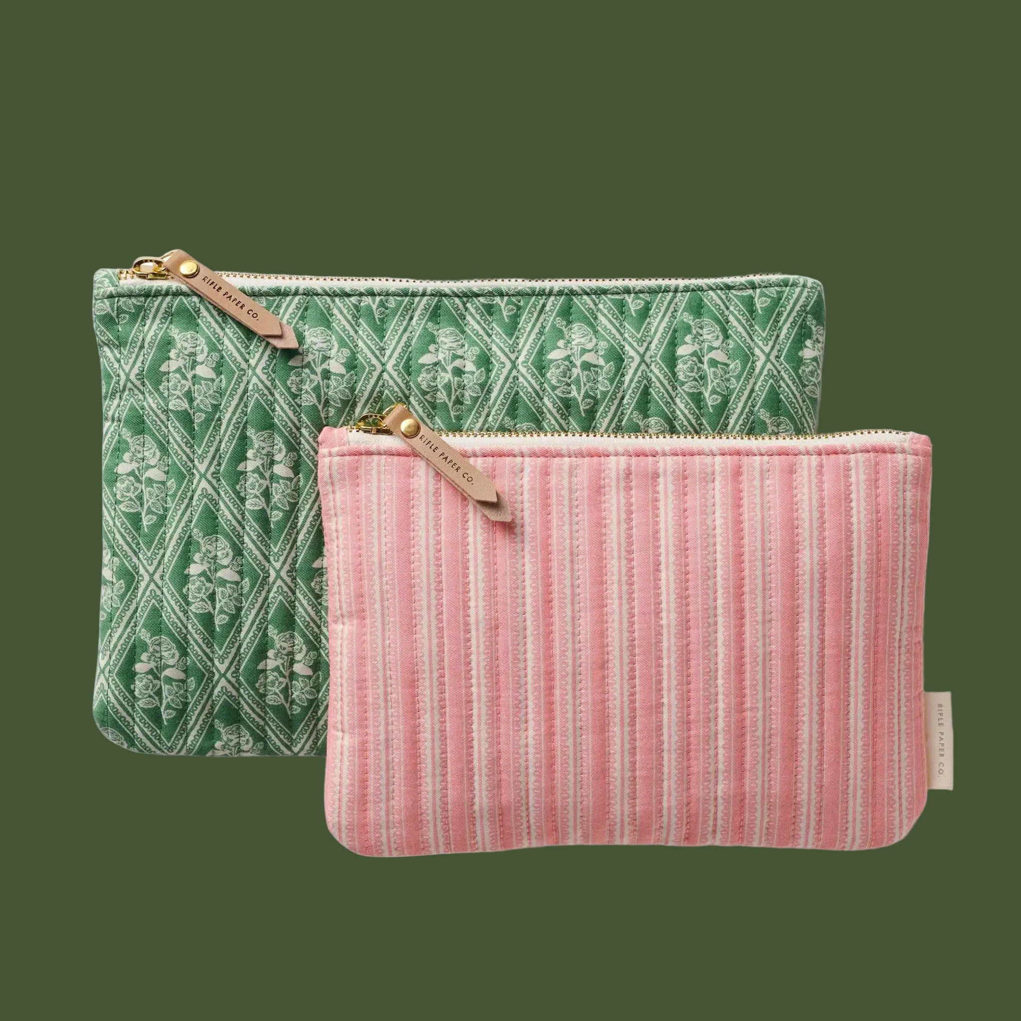 Two patterned pouches, one green with floral design and one pink with striped pattern, on a white background.
