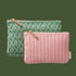 Two patterned pouches, one green with floral design and one pink with striped pattern, on a white background.