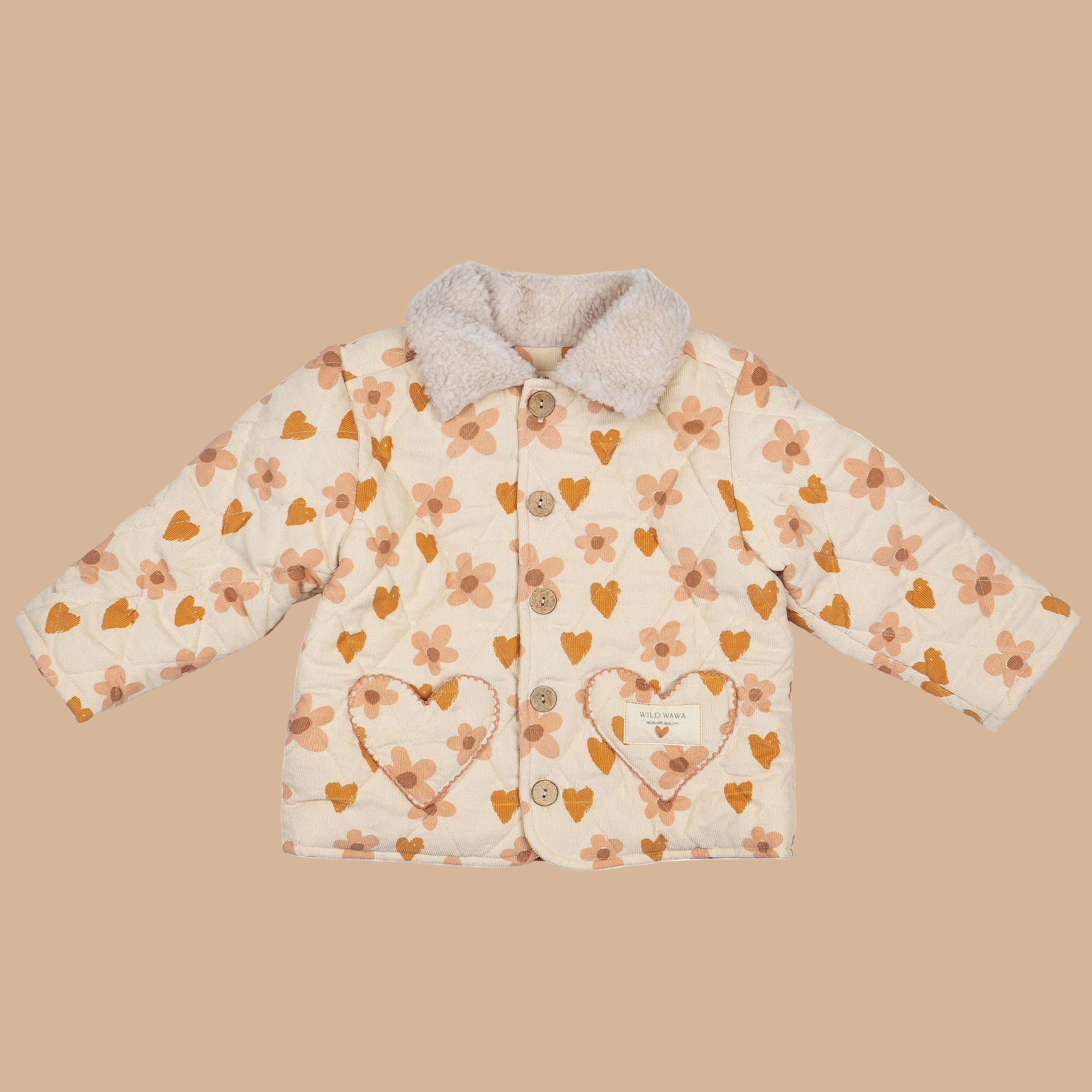 A quilted children's jacket with a peachy pink floral and heart pattern and a sherpa collar. 