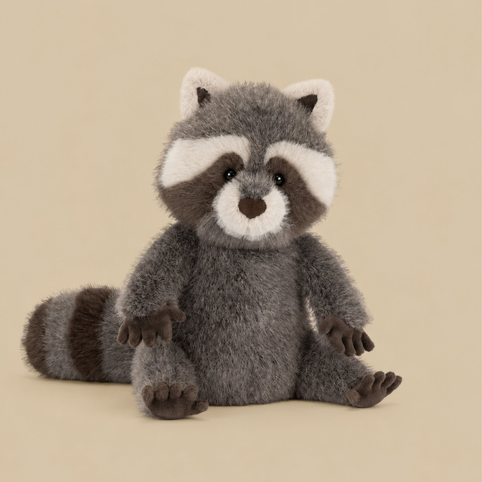 Plush raccoon toy on a beige background
