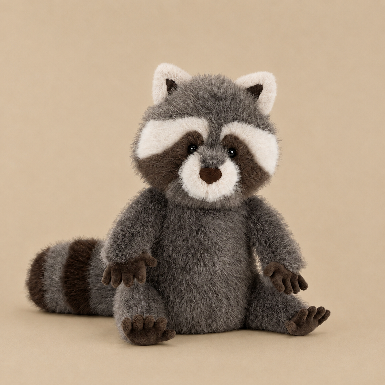 Plush toy raccoon on a beige background