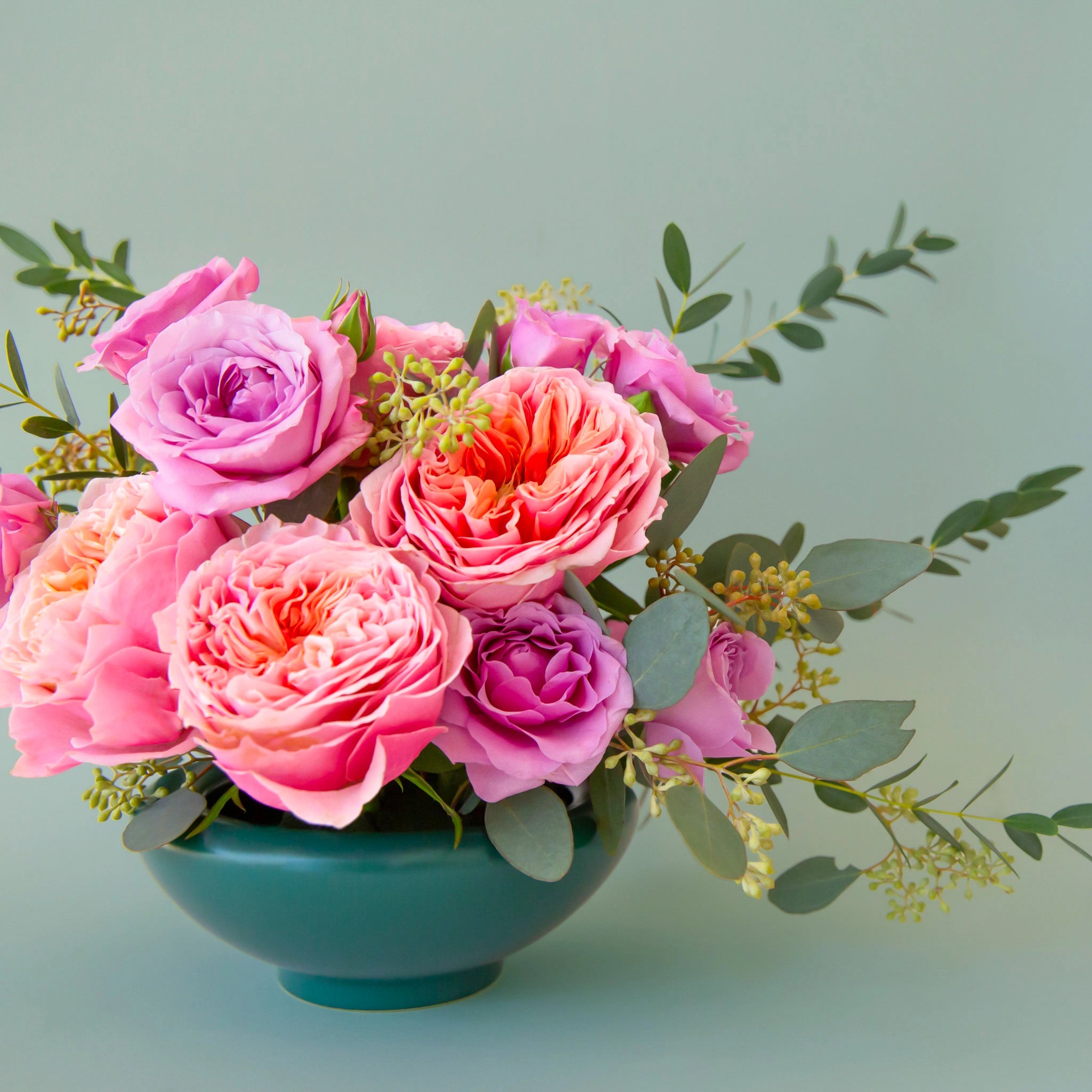 A blue ceramic bowl with garden roses.