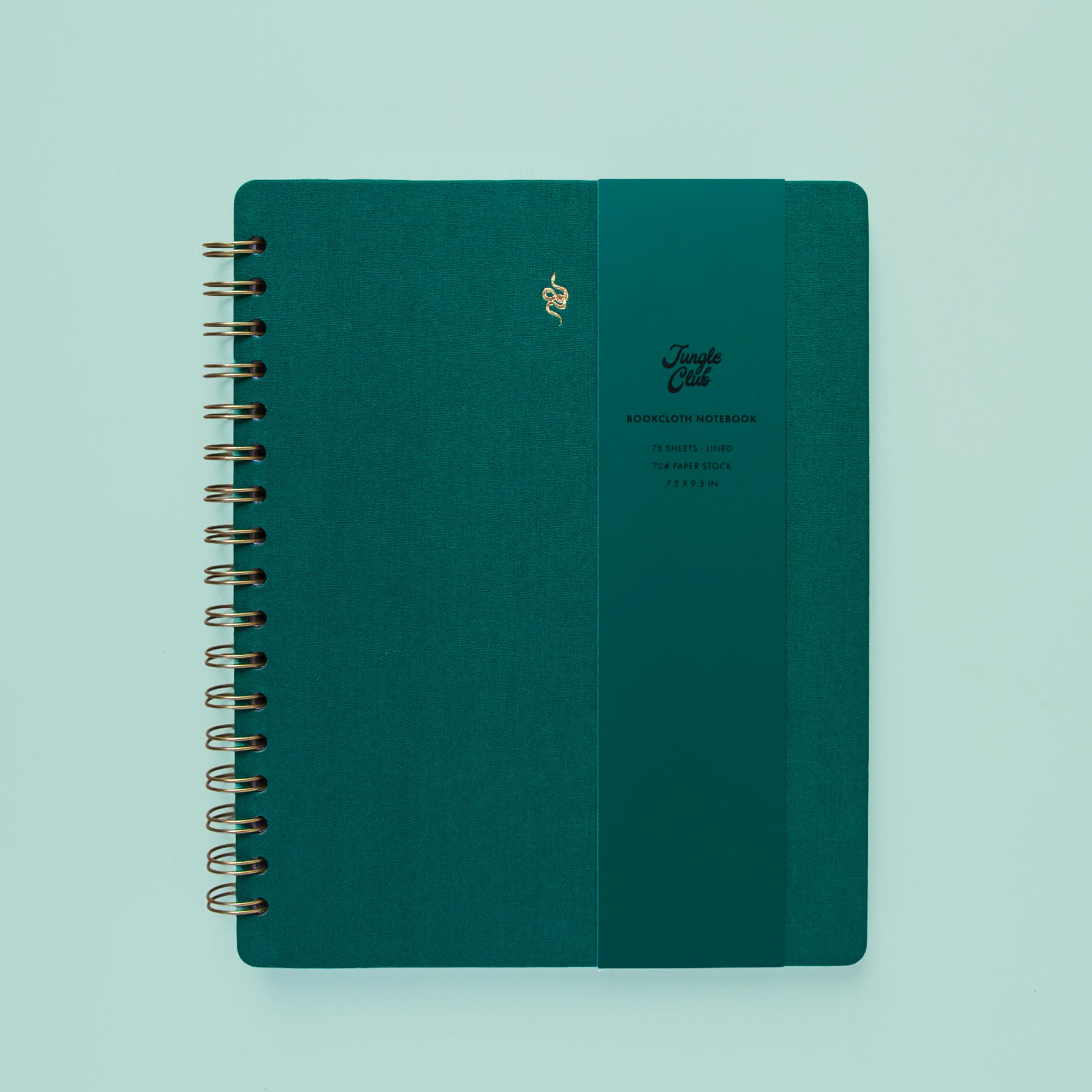 A dark green spiral bound notebook with a gold foiled snake graphic in the top center. 