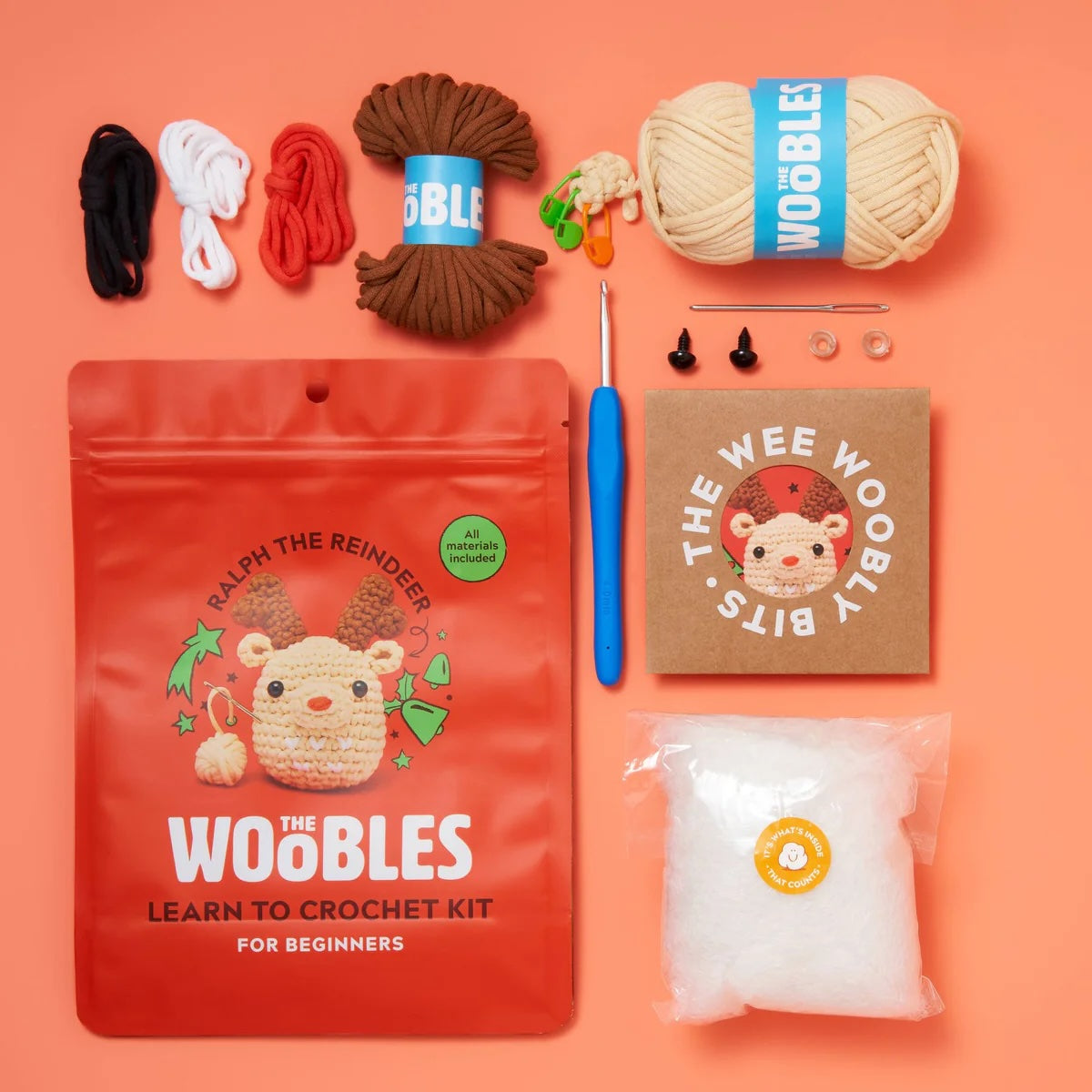 A flat lay of a red package with a crochet reindeer on it.  The package reads "The woobles crochet kit"
