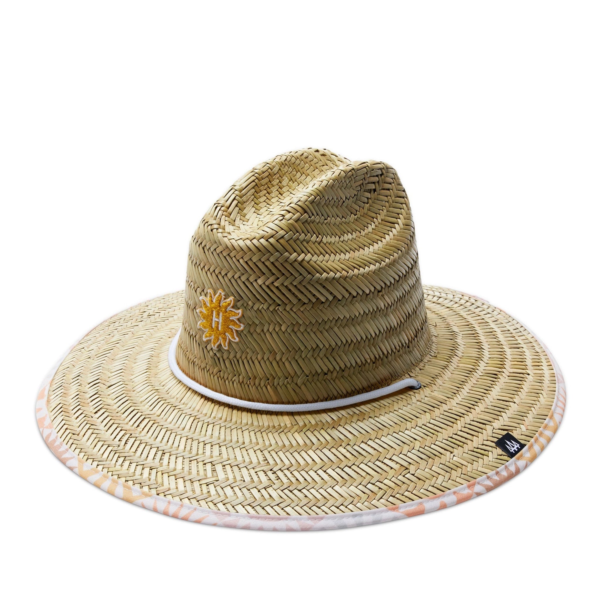 On a white background is a neutral colored straw sun hat with a neckstrap and a light pink and light orange sun design on the underside of the brim.