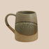 A green and tan speckled reactive glaze mug. 
