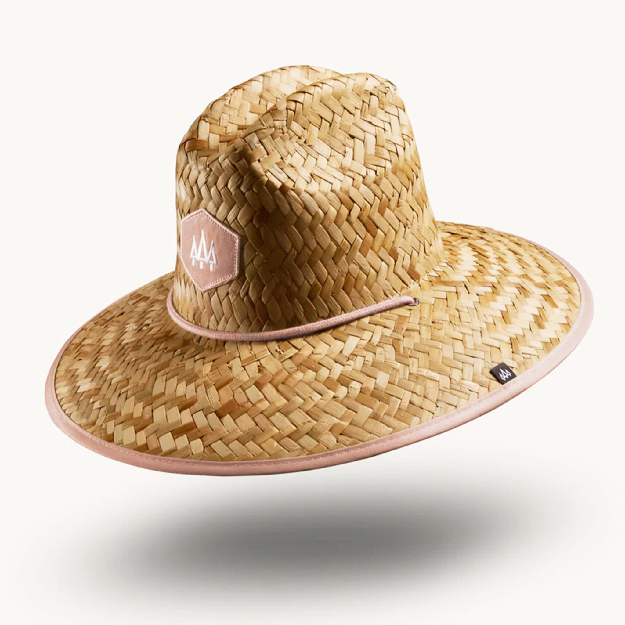 On a white background is a straw hat with a neutral mauve / tan brim underneath and neck strap.