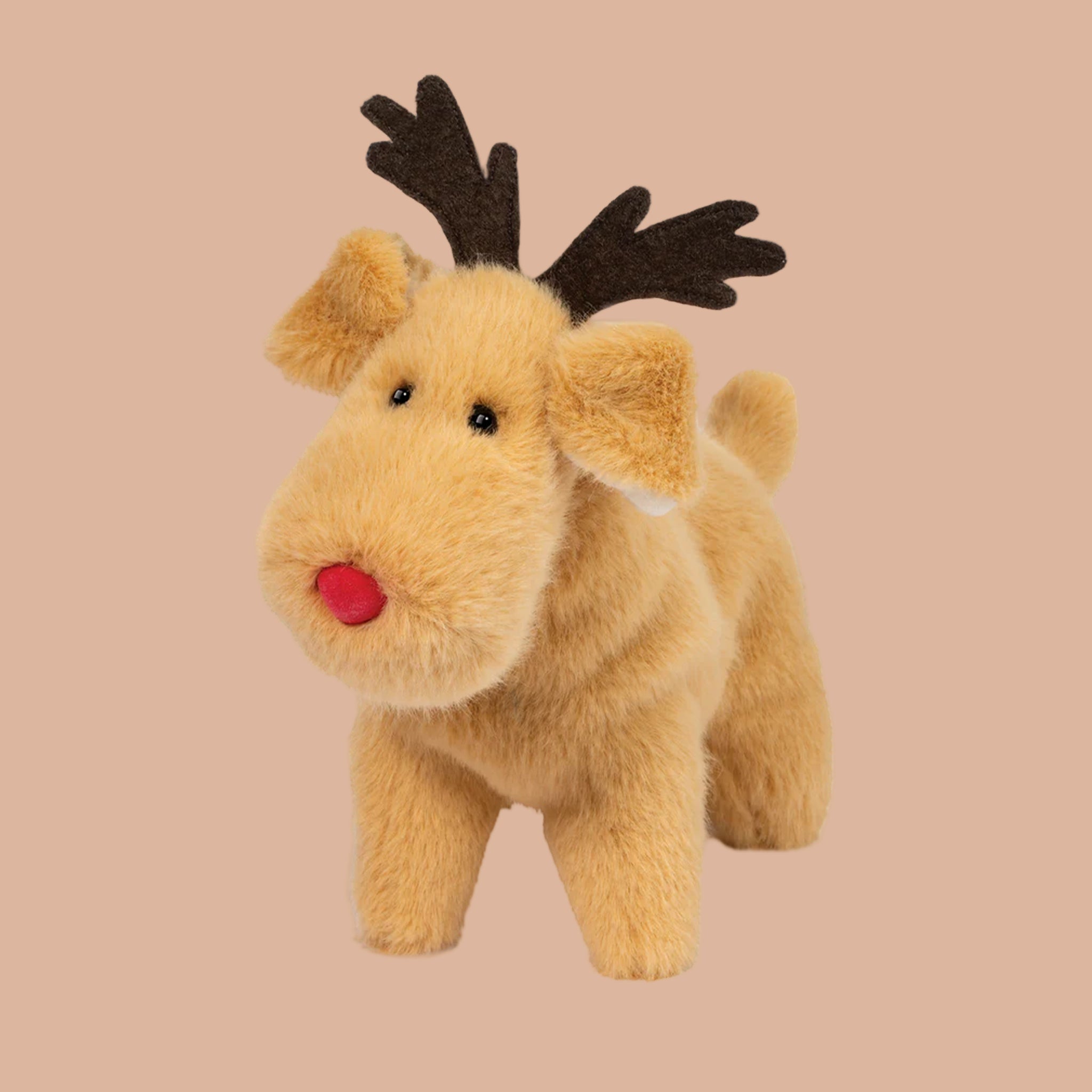 a tan reindeer shaped stuffed animal with a red nose. 